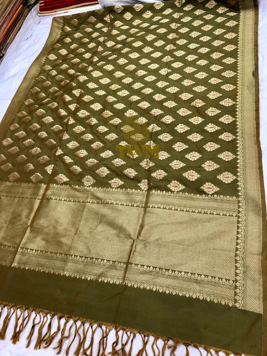 Green and gold patterned fabric with a star design on a white background