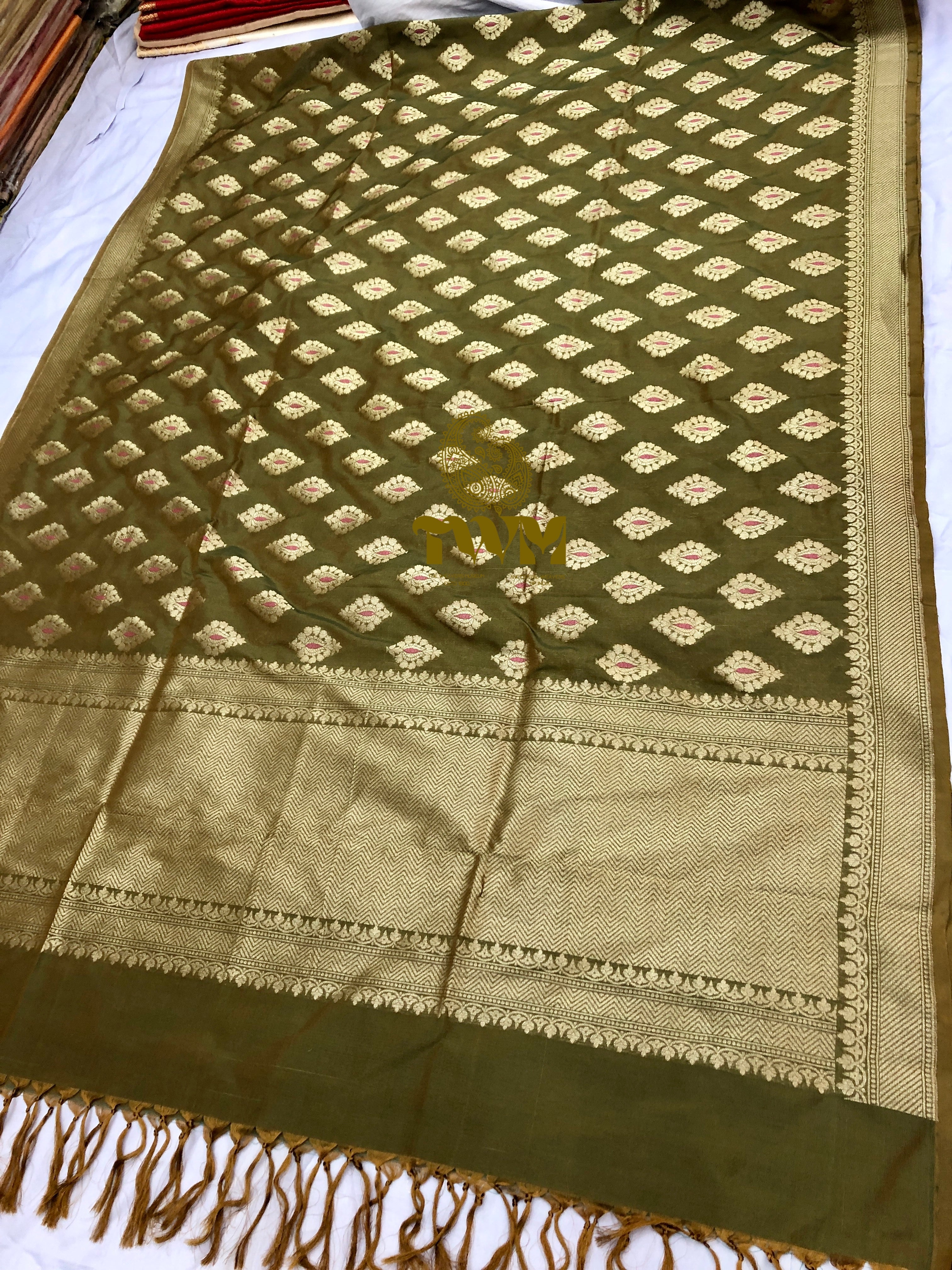 Green and gold patterned fabric with a star design on a white background