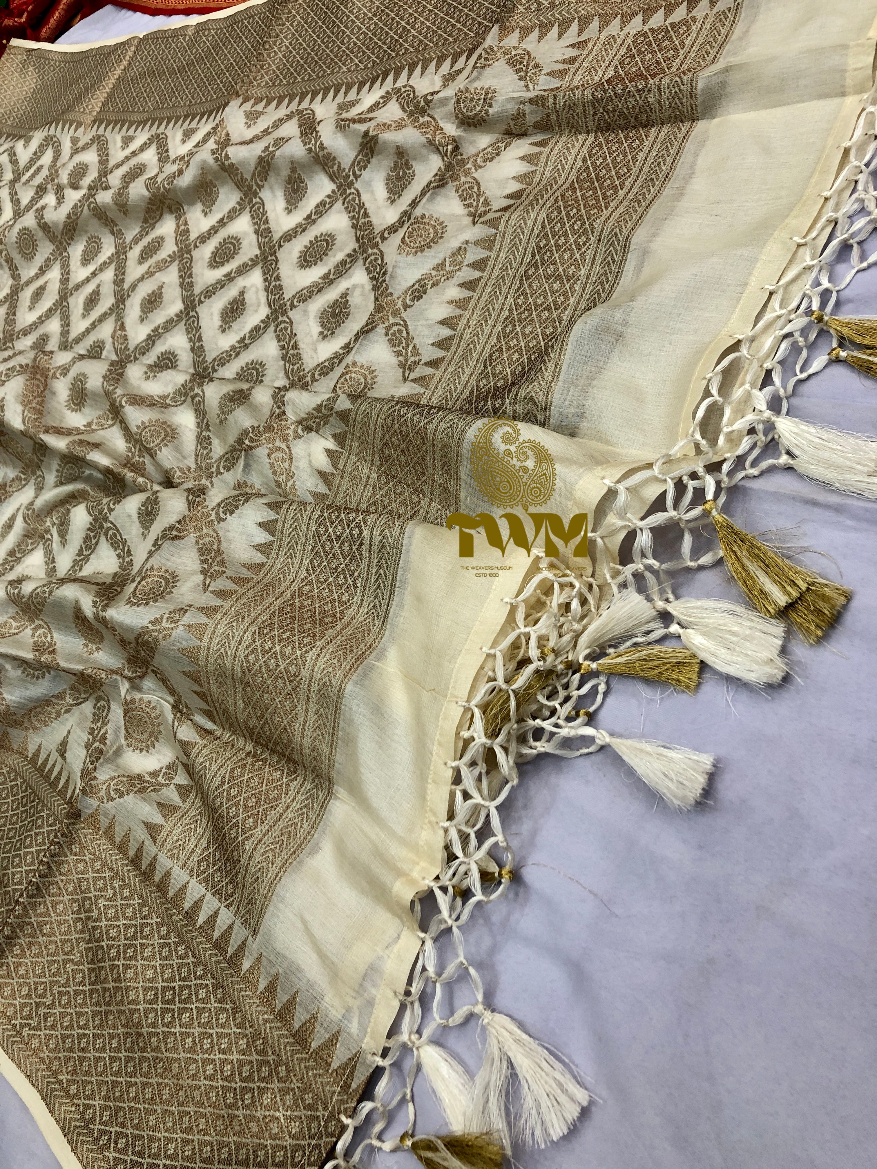 Textured fabric with geometric patterns and tassels on a light gray background