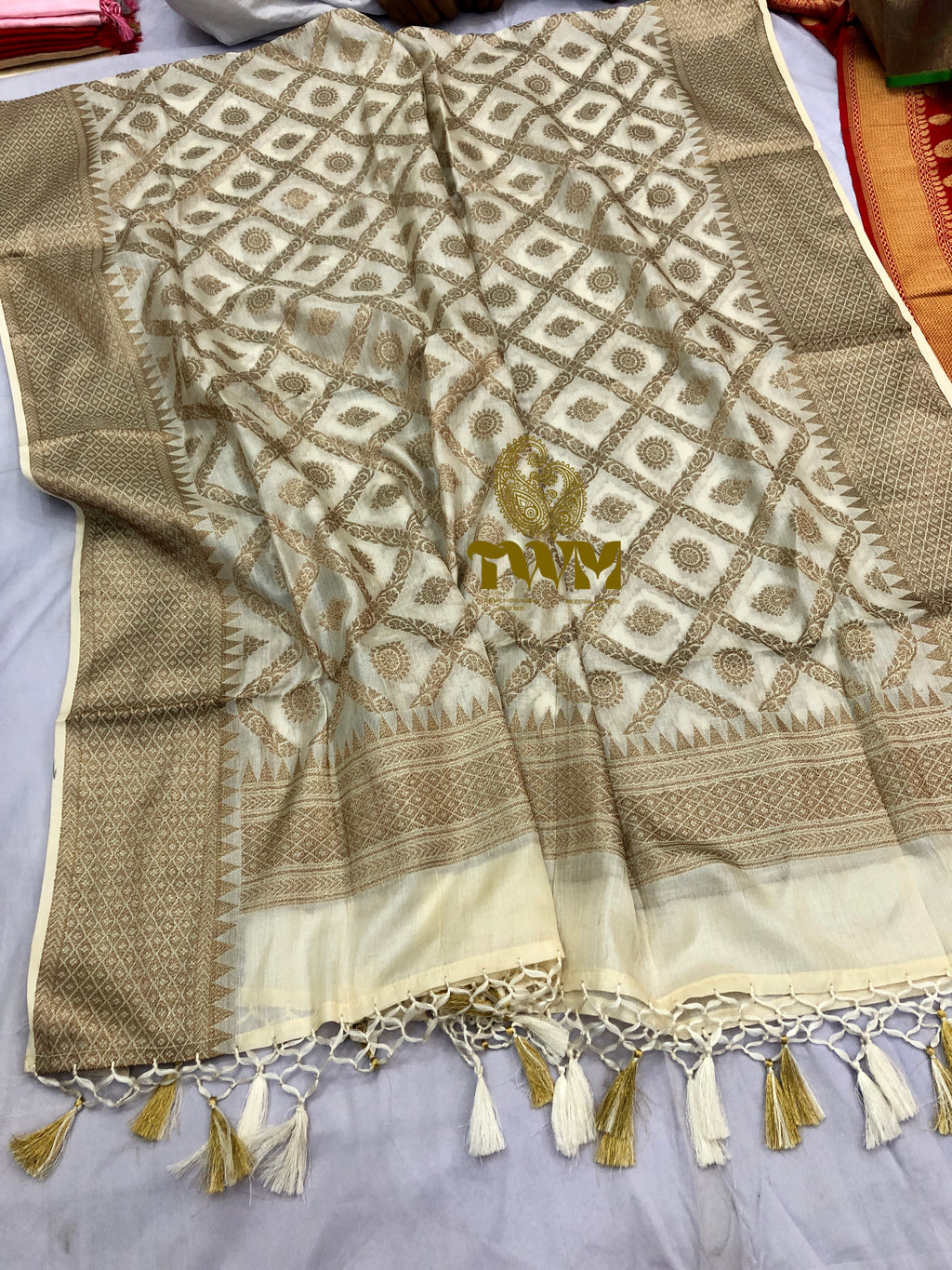 Beige and brown patterned fabric Dupatta with tassels on a plain background