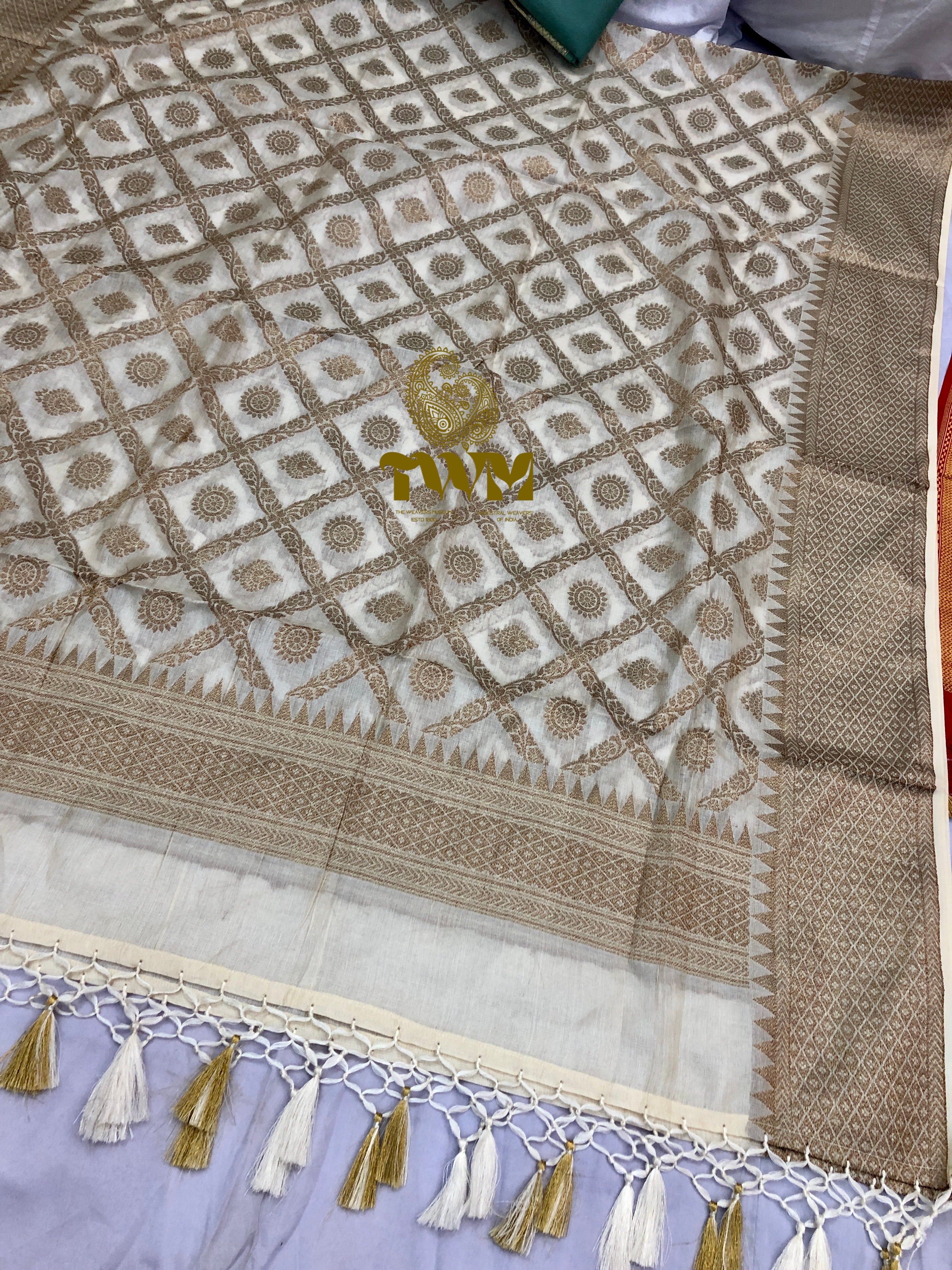 Close-up of a patterned fabric with tassels on a light background