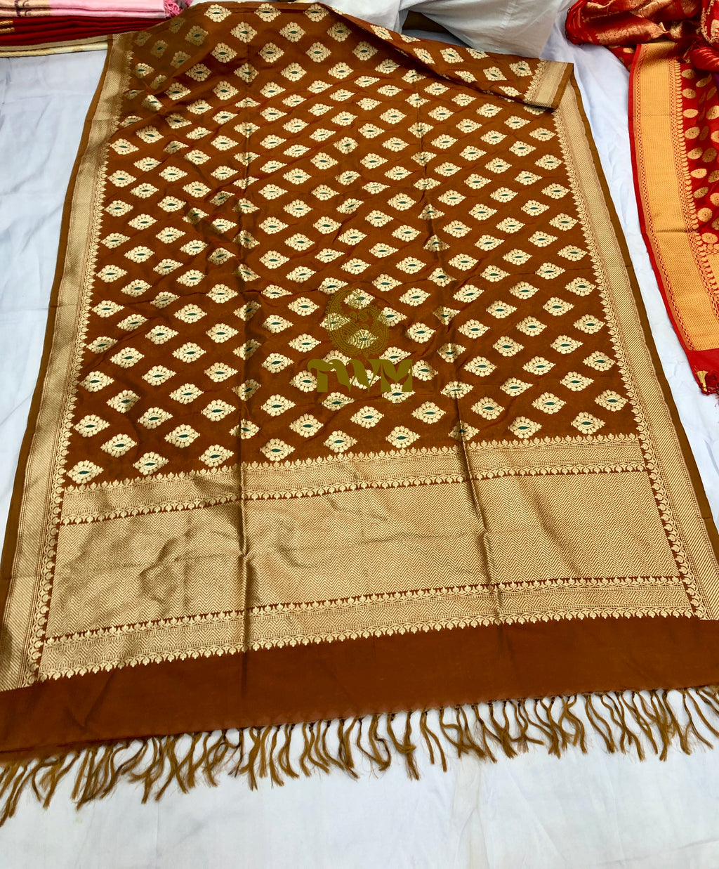 Brown and beige patterned fabric with fringes on a white background