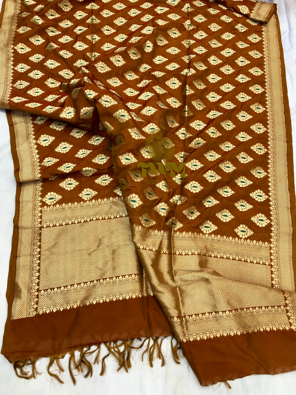 Brown and beige patterned fabric with tassels on a white background
