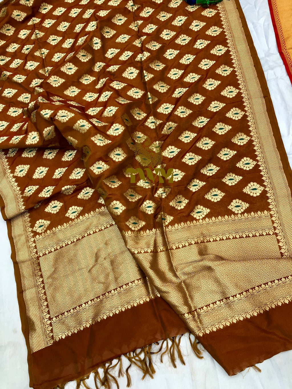 Brown and beige patterned fabric with fringes on a white background