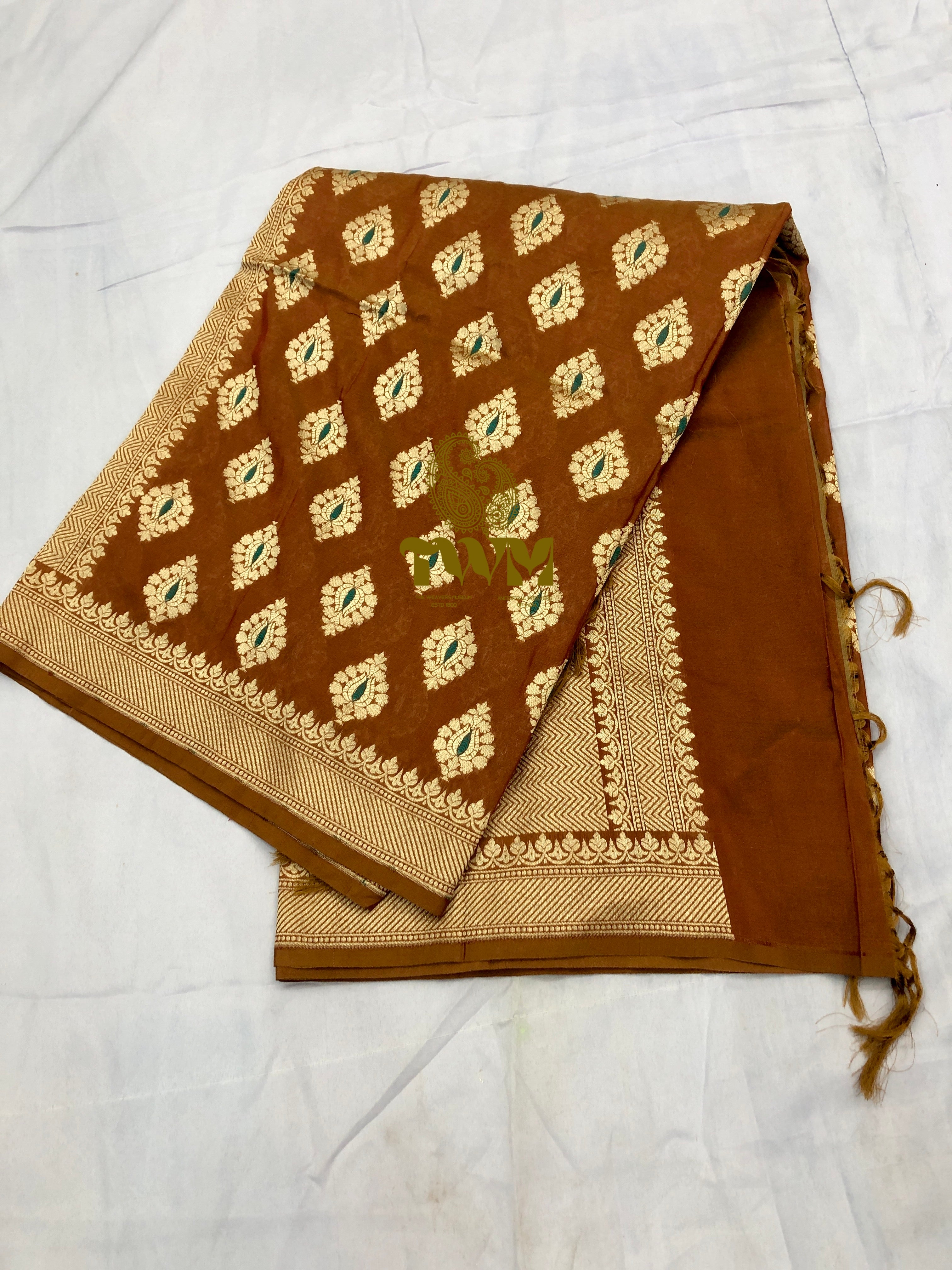 Brown fabric with gold and green patterns on a white background