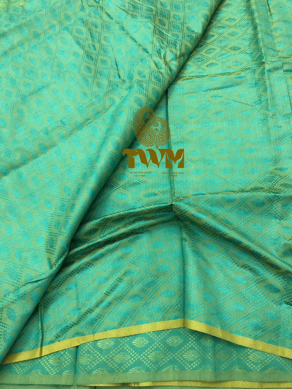 Teal fabric with gold patterns and a visible brand logo