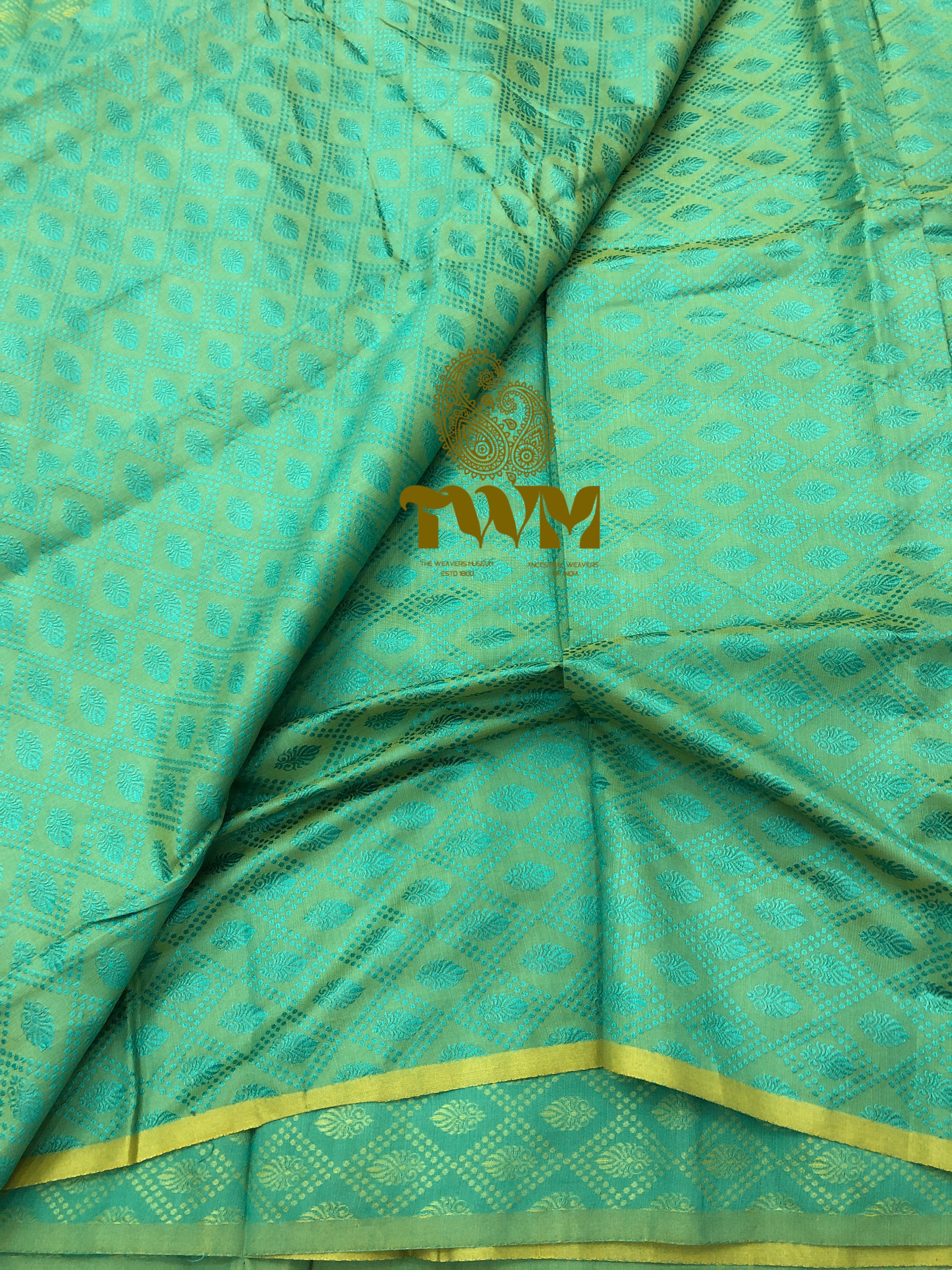 Teal fabric with gold patterns and a visible brand logo