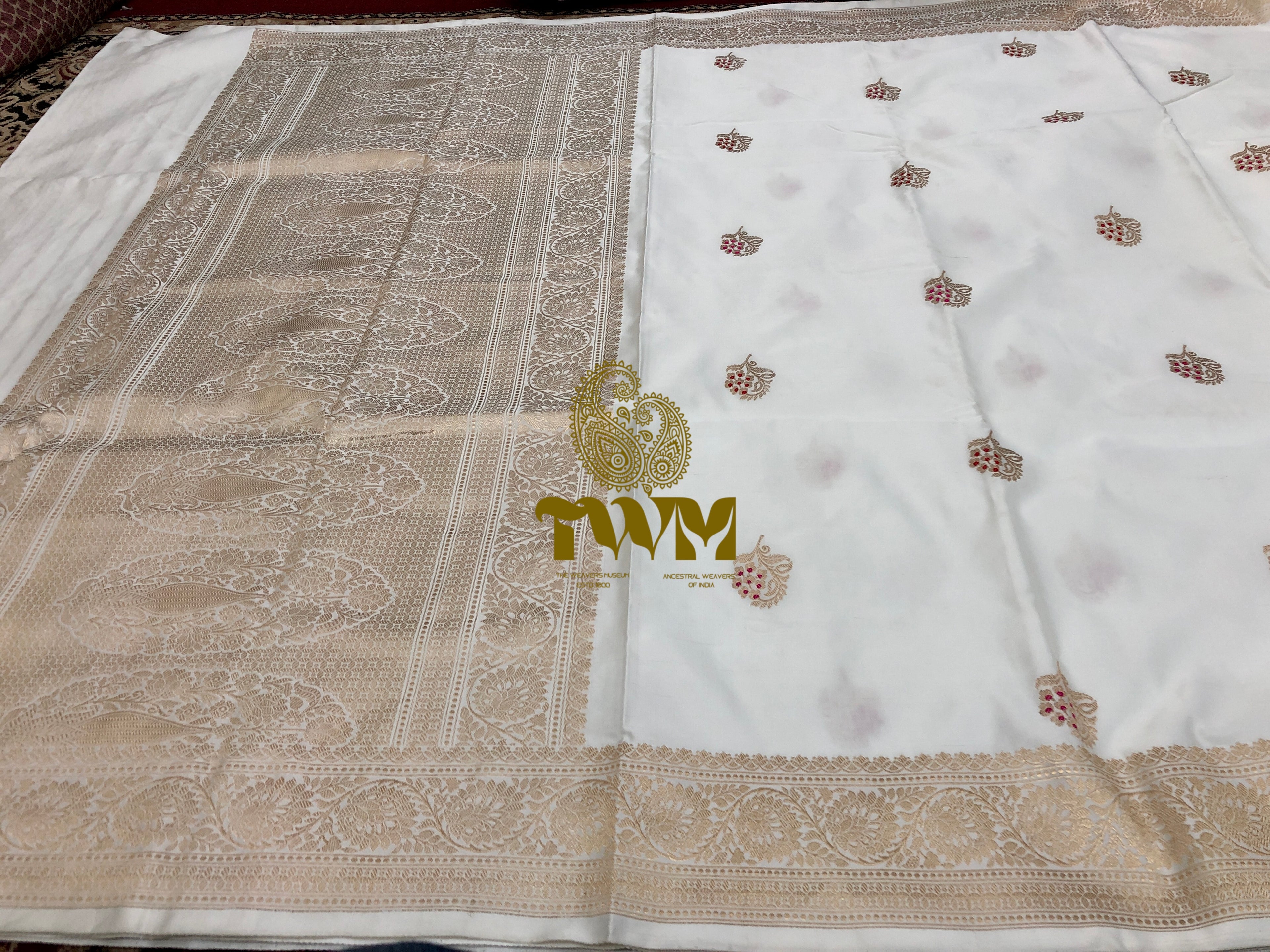 White fabric with gold embroidery and a logo in the center