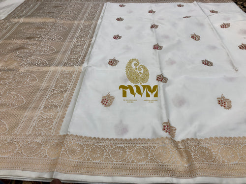White fabric with gold embroidery and a logo on a textured surface