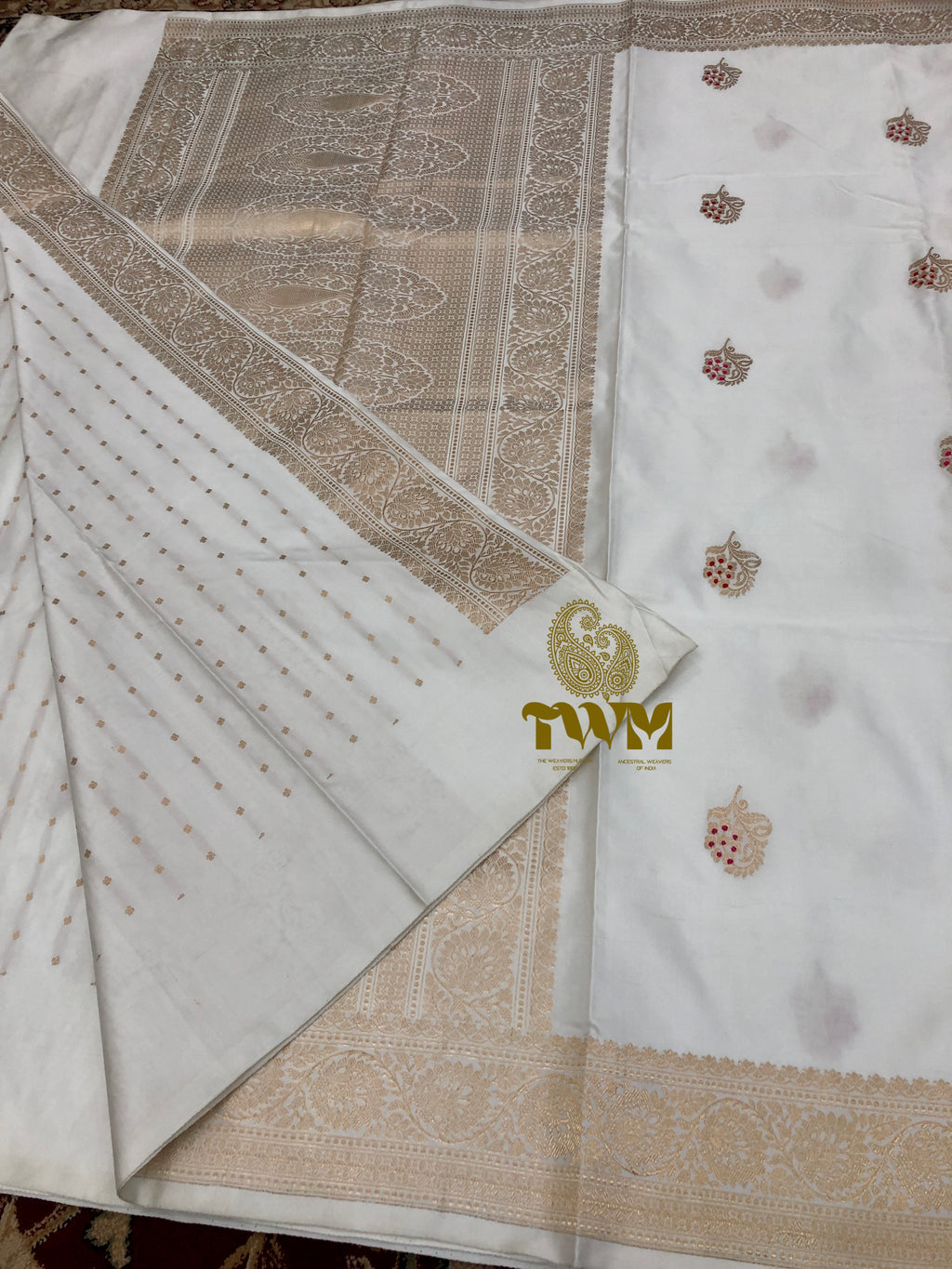 White fabric with intricate brown patterns and a brand logo in the corner.