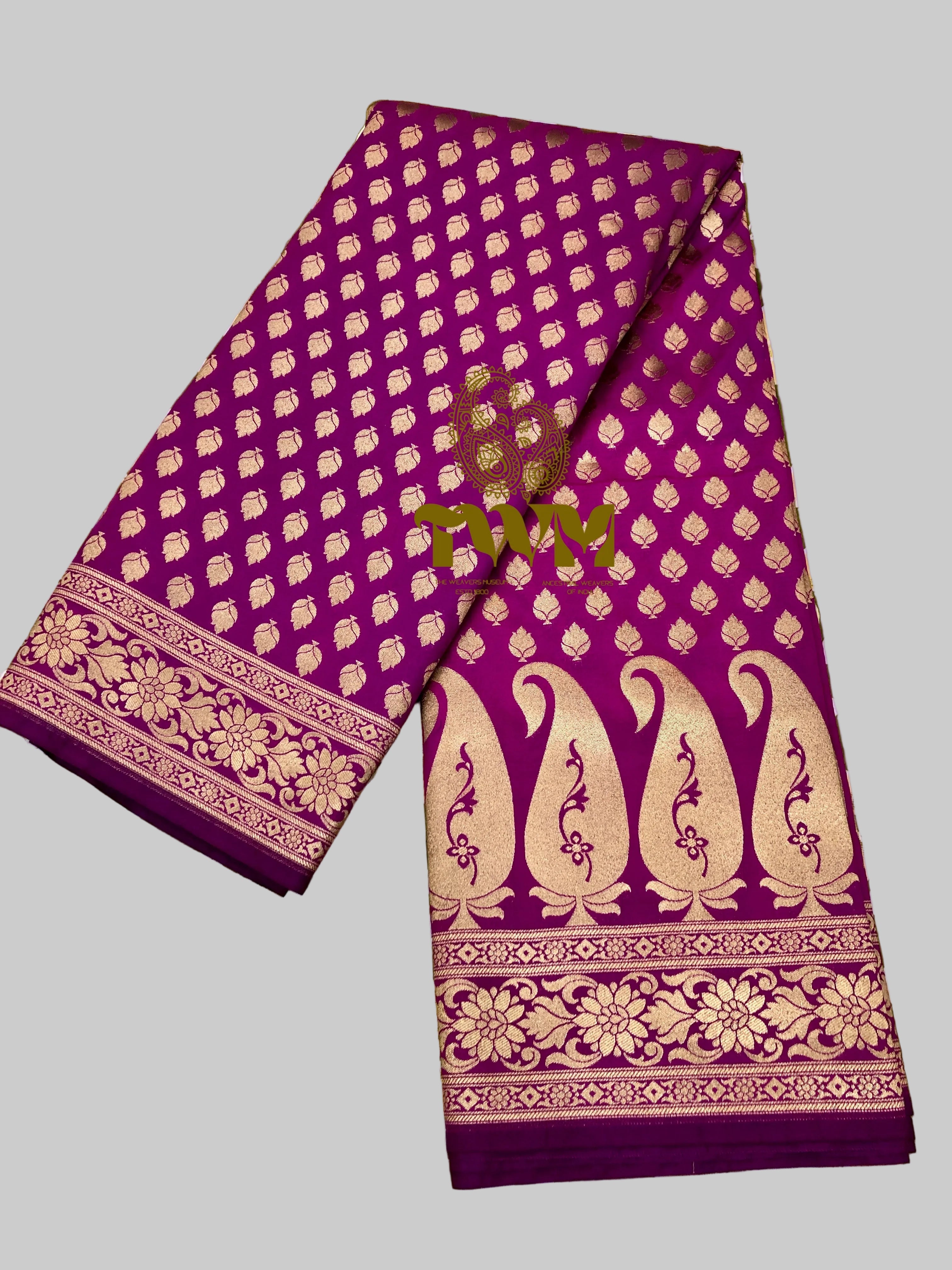 Purple fabric with gold patterns on a green floral background