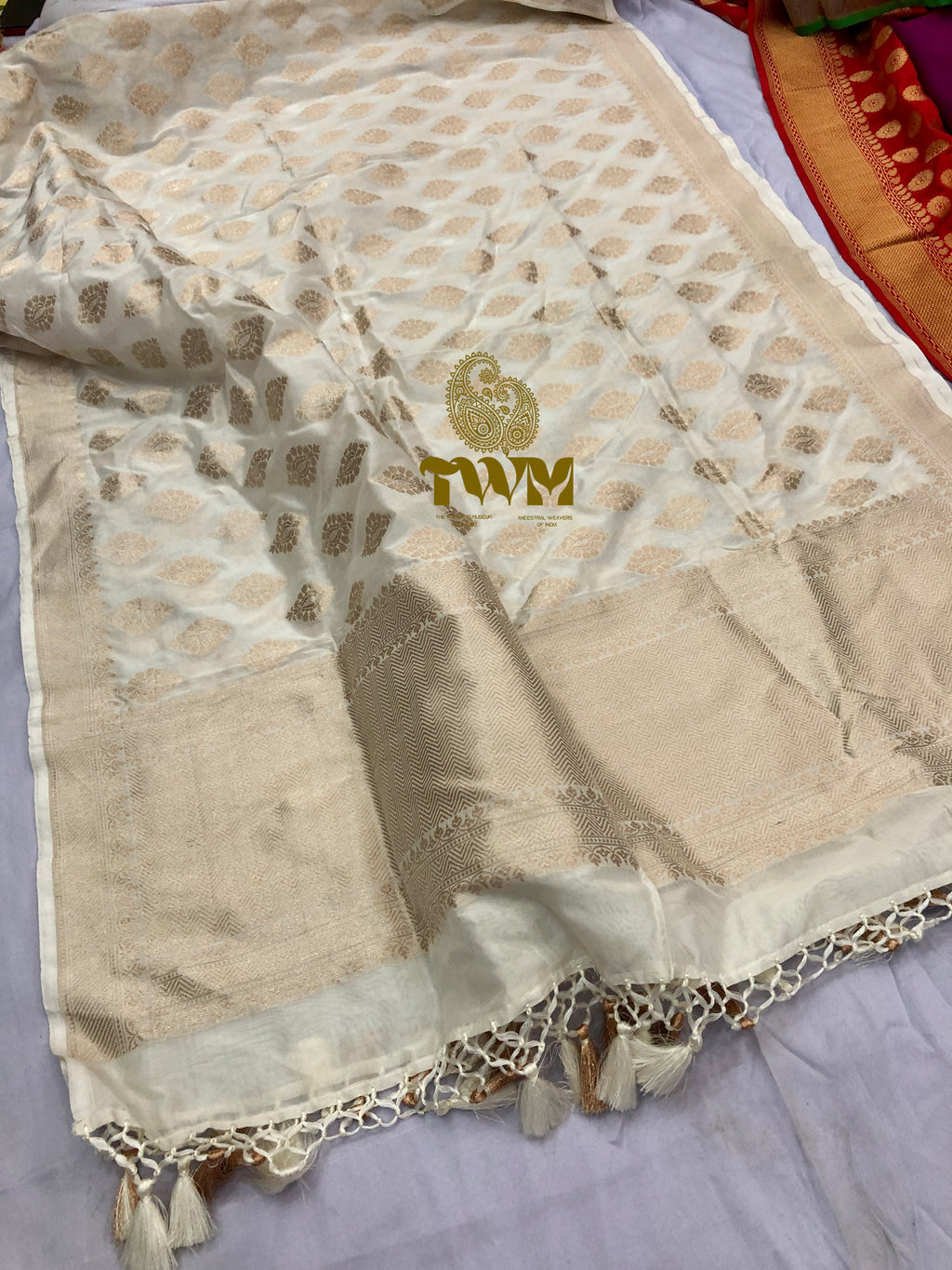 Beige fabric with gold patterns and a brand logo on a white background