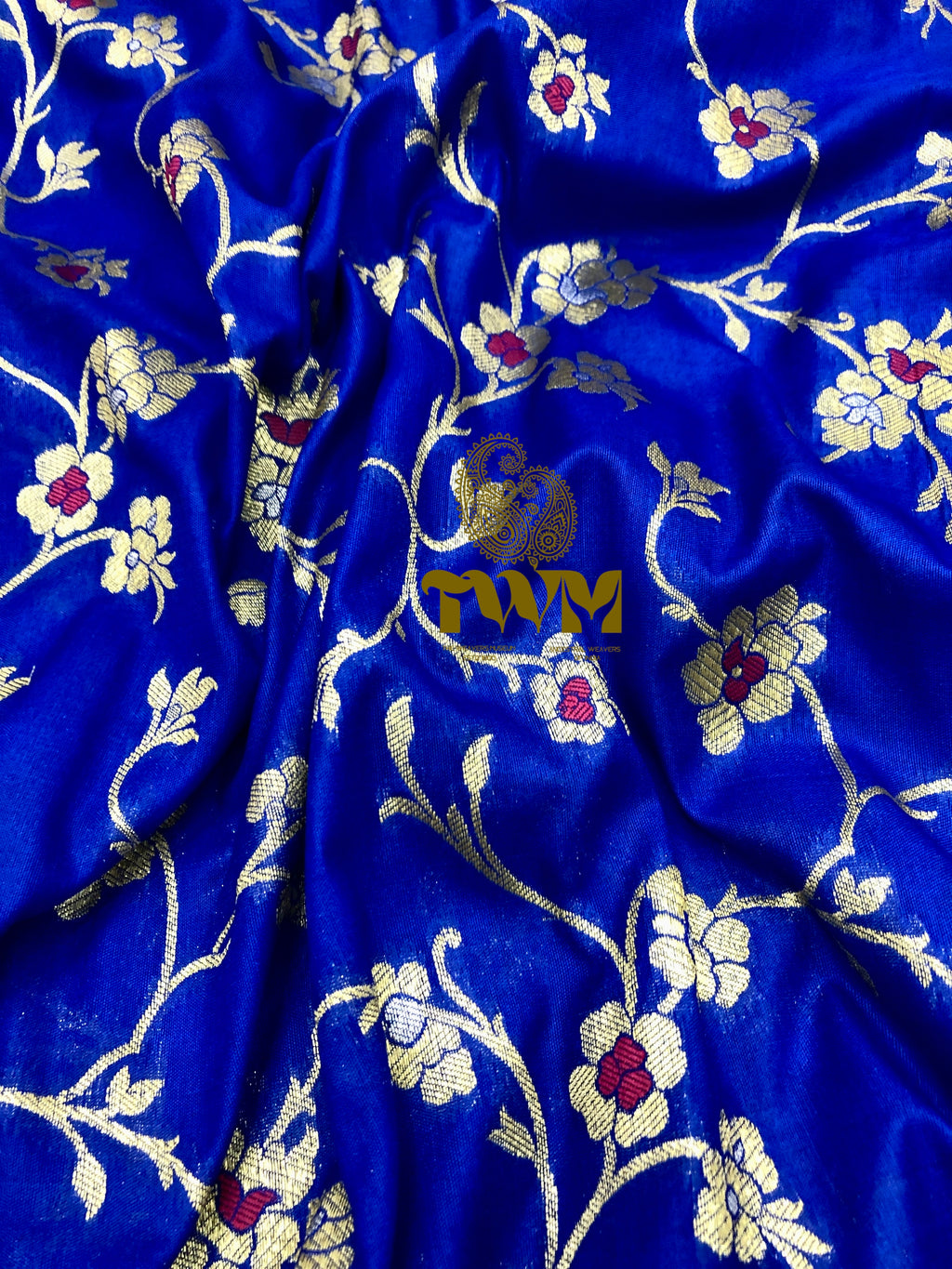Blue fabric with floral embroidery and 'TWM' branding