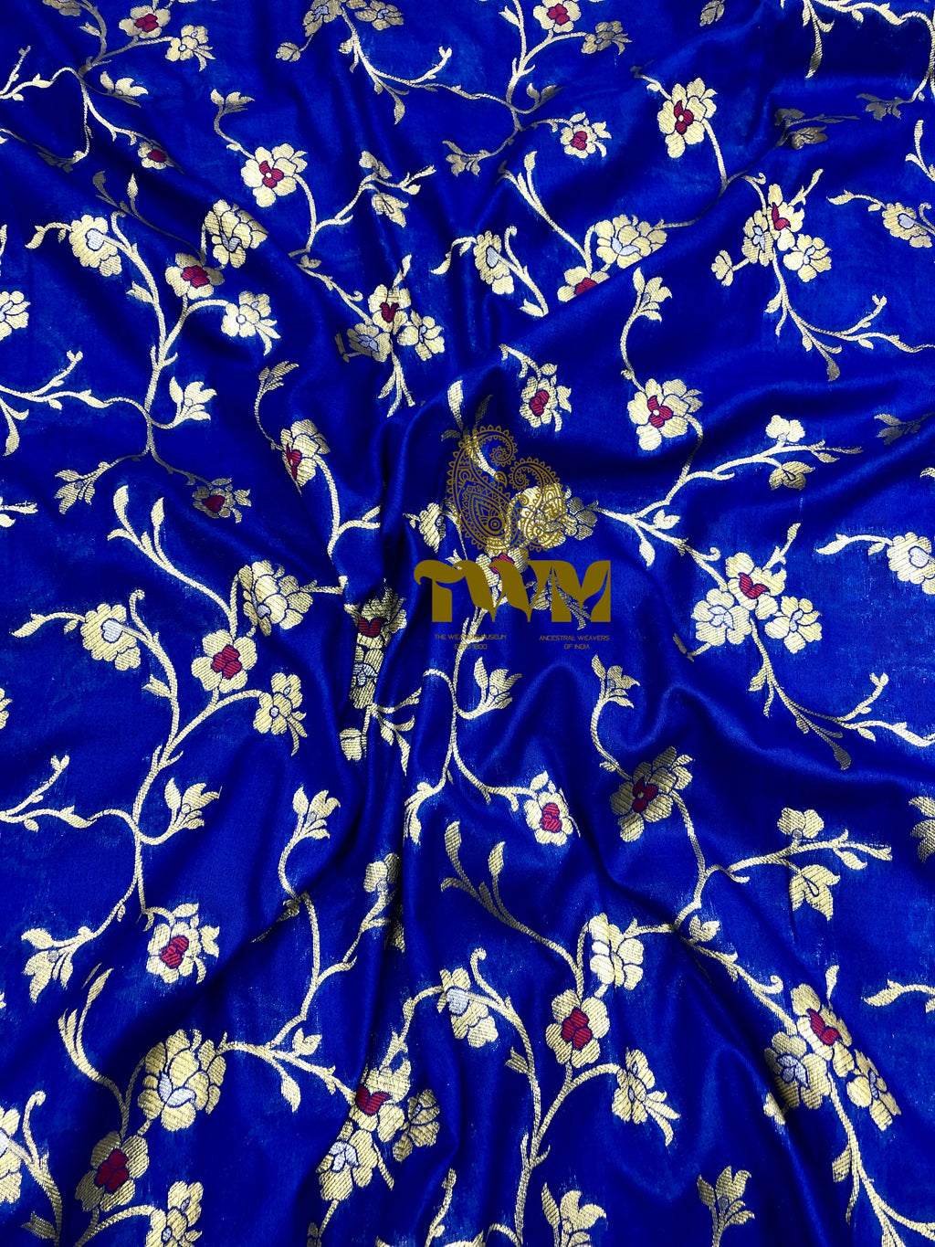 Blue fabric with floral patterns and a brand logo in the center