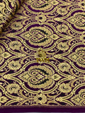 Close-up of intricate gold embroidery on purple fabric