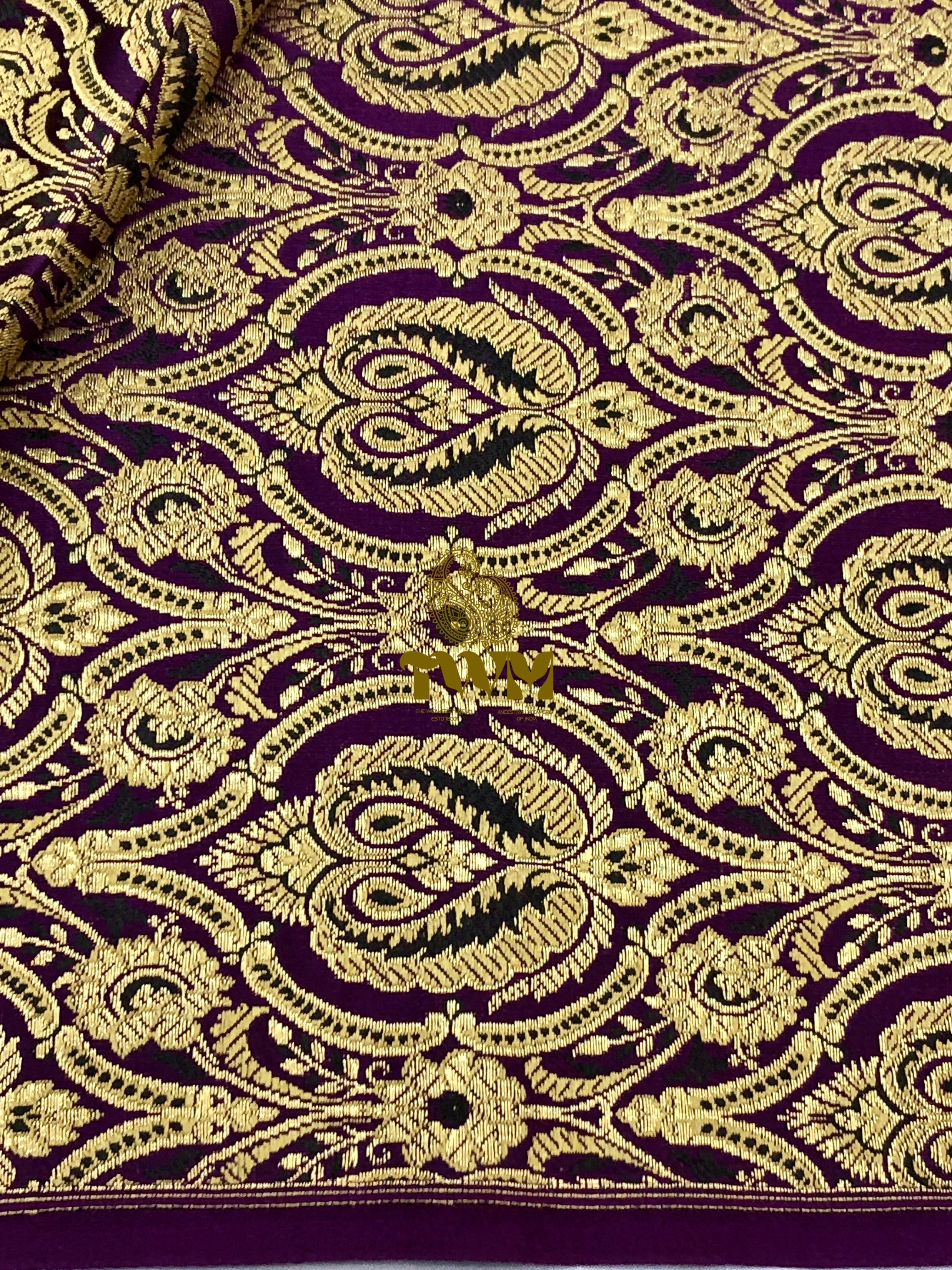 Close-up of intricate gold embroidery on purple fabric