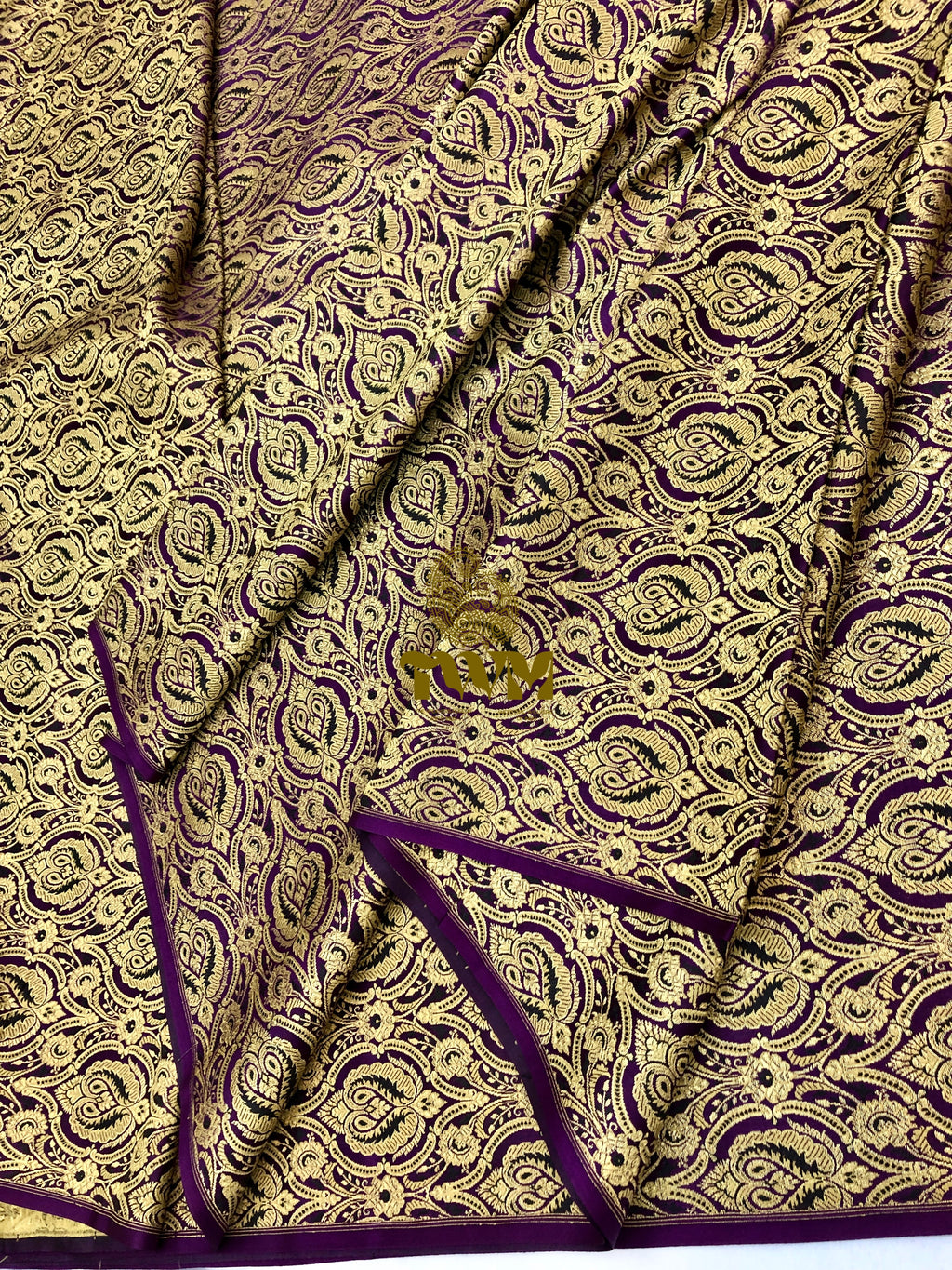 Close-up of a patterned fabric with purple and gold design