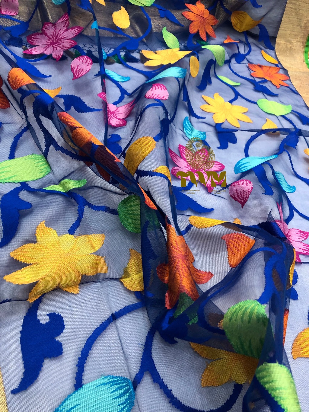 Colorful hand Woven fabric with floral and fish patterns on a wooden surface