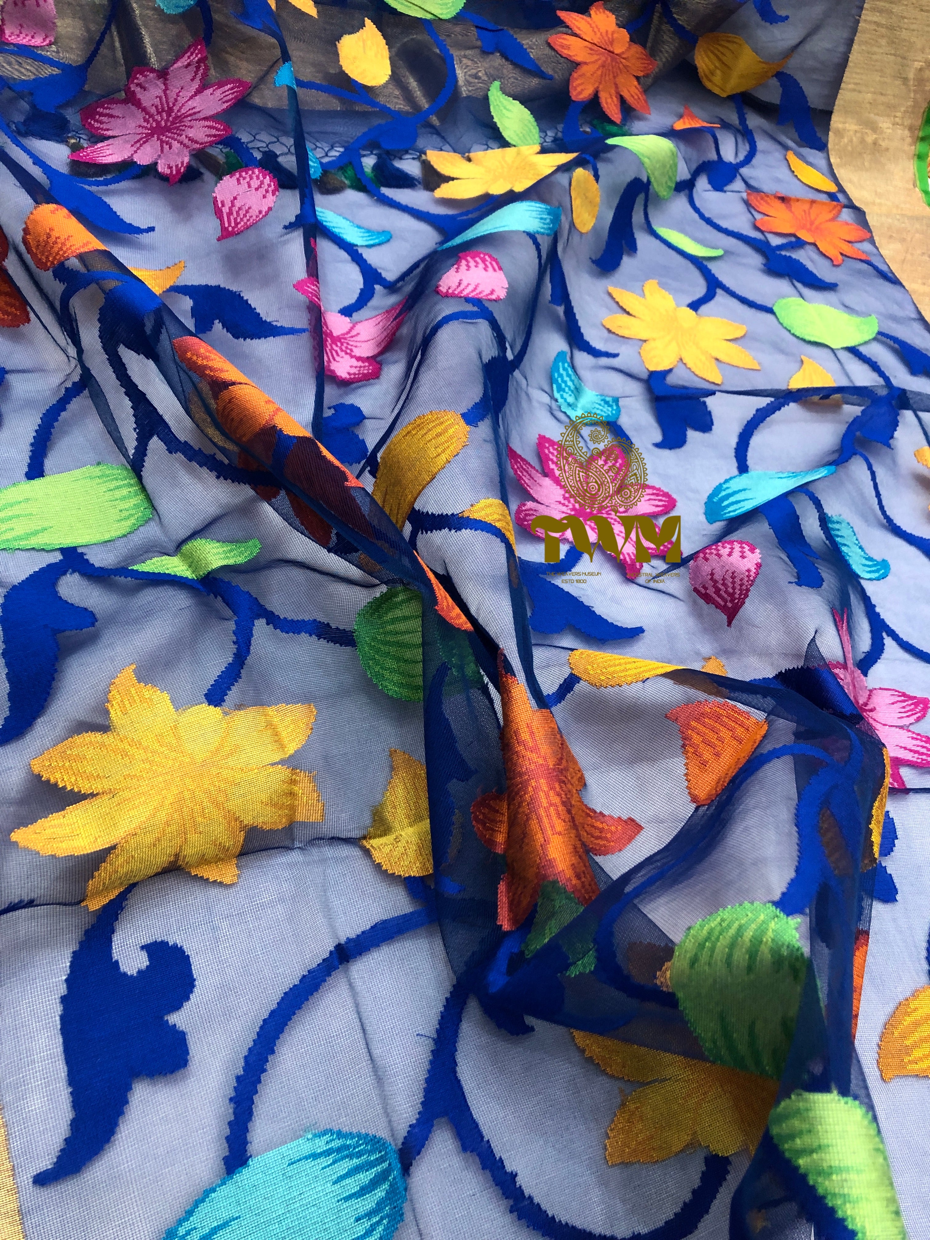 Colorful hand Woven fabric with floral and fish patterns on a wooden surface