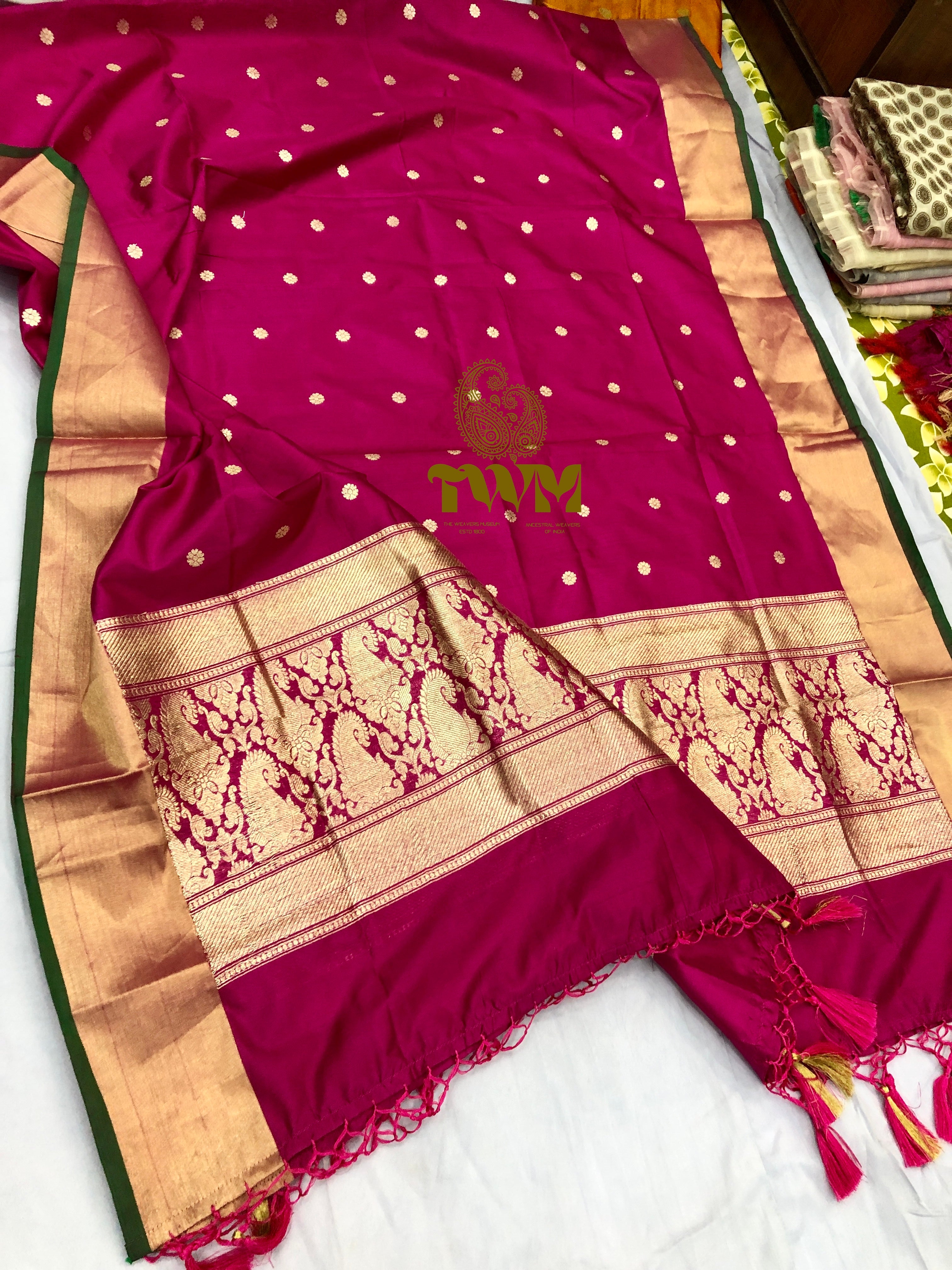 Rani magenta  saree with gold patterns on a white background