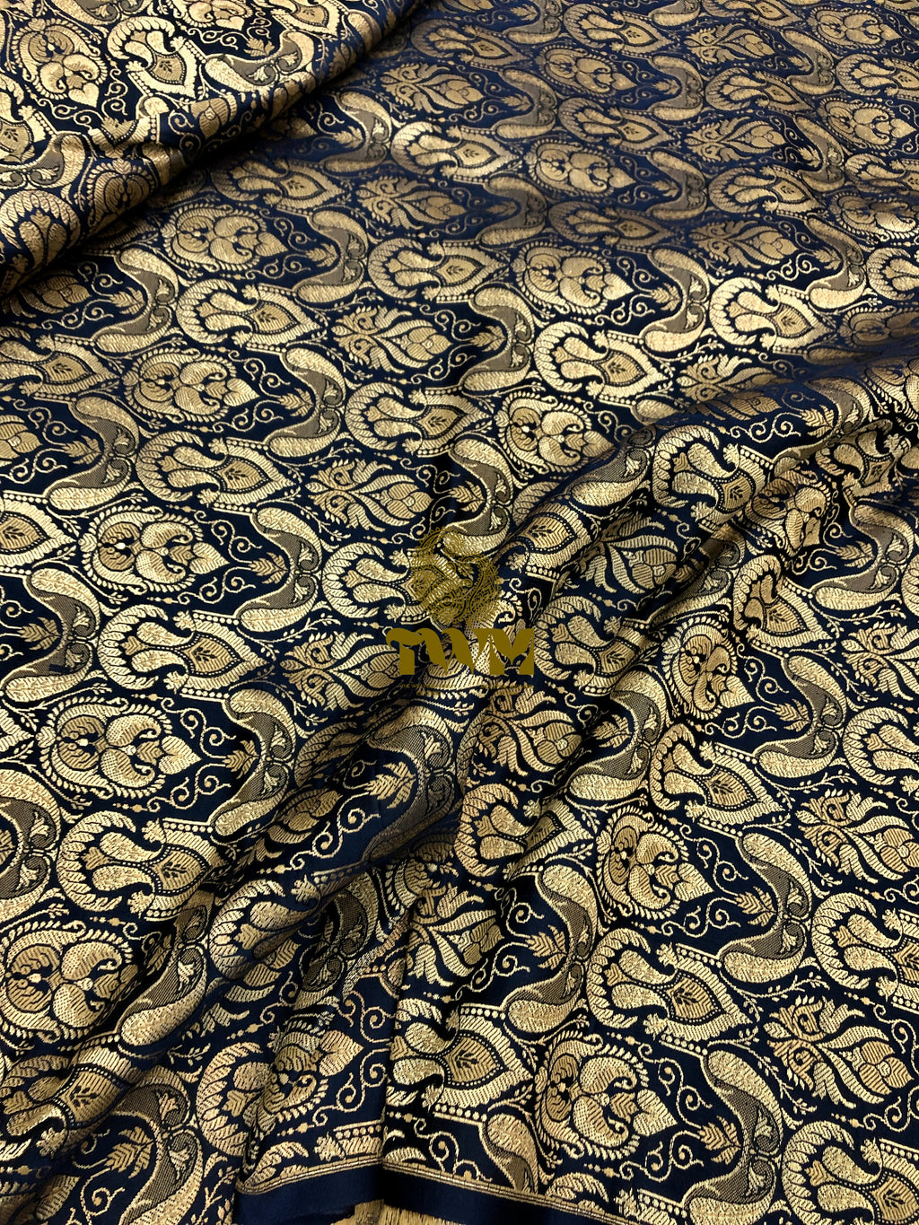 Patterned fabric with intricate design in gold and navy blue