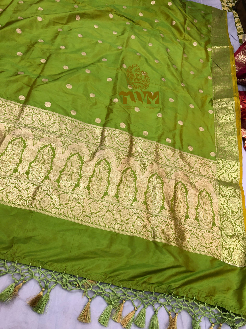 Olive Green with gold patterns and tassels on a white surface