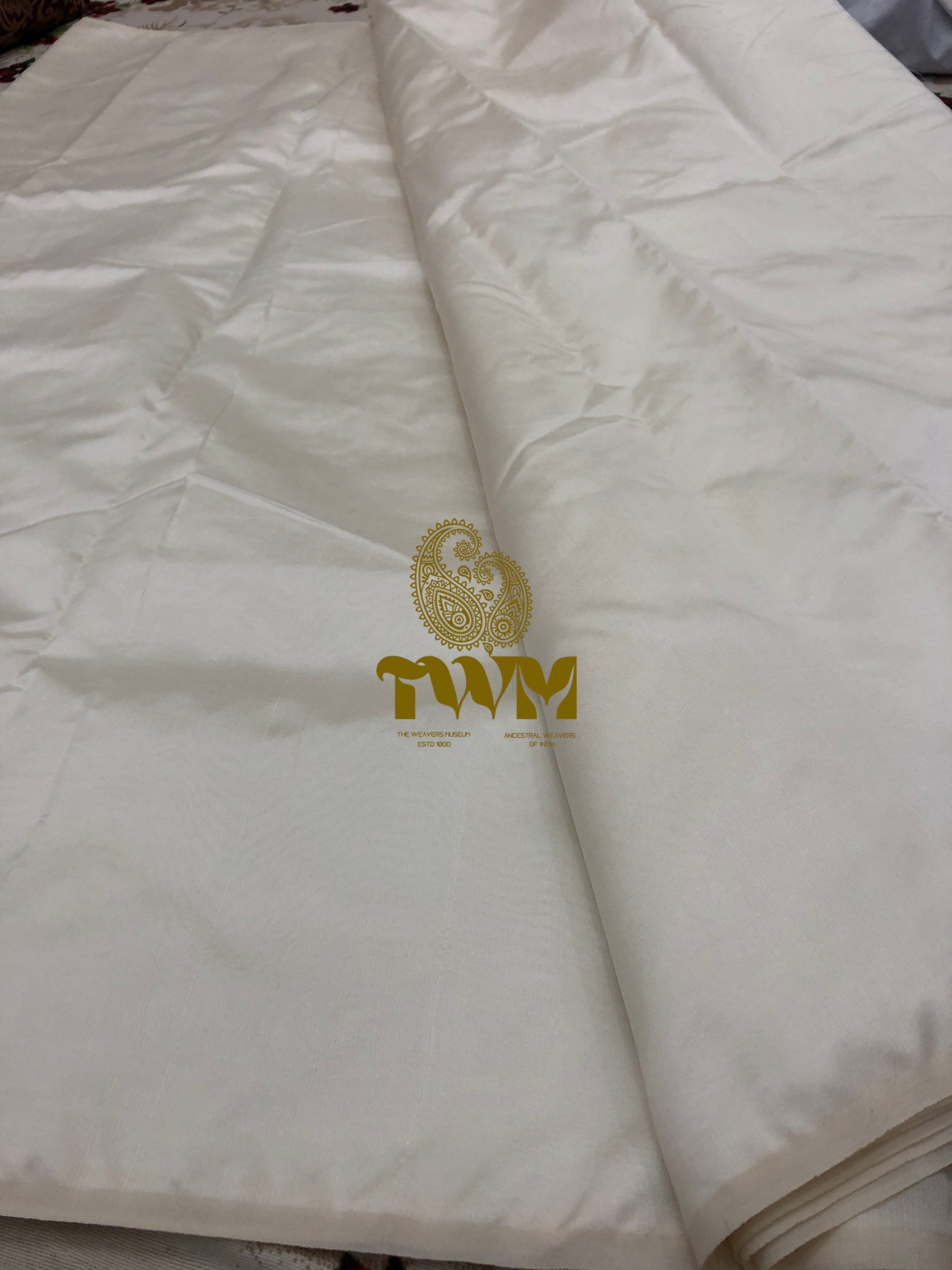 White fabric with a gold logo and text on a white background