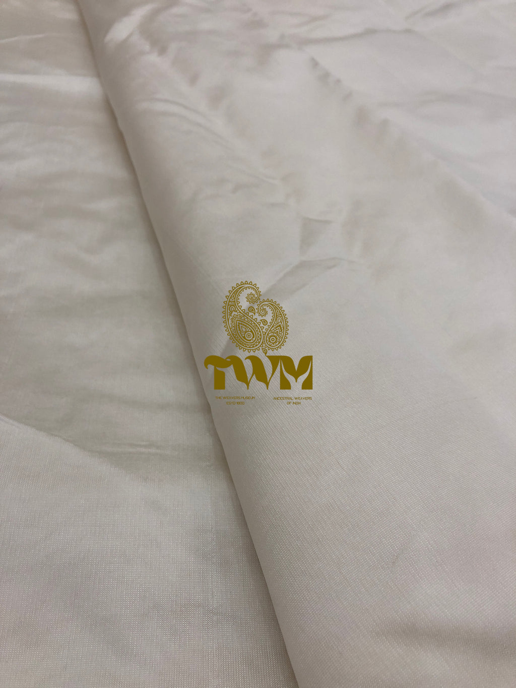 White fabric with gold logo and text on a white background