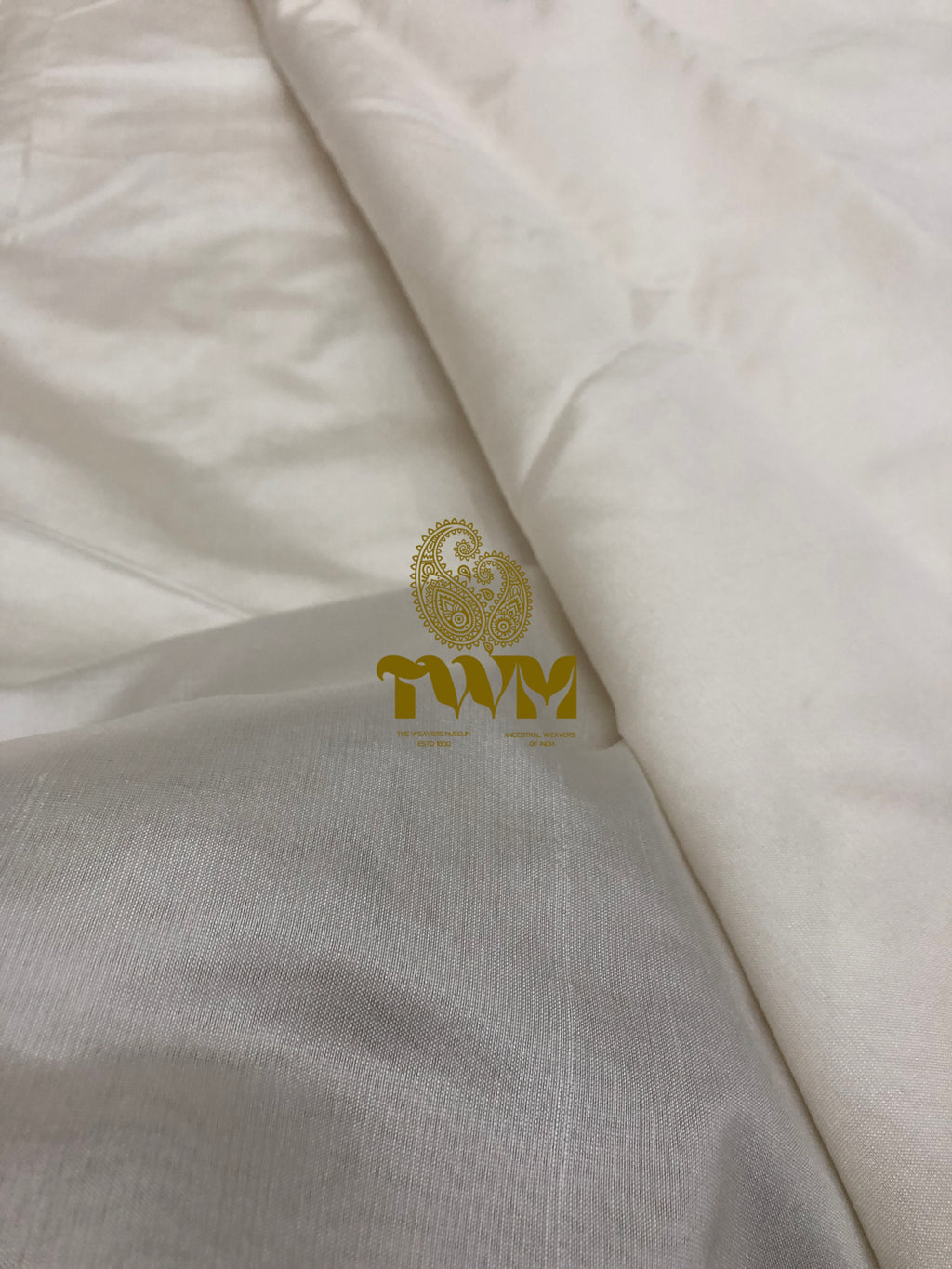White fabric with a gold logo on a white background