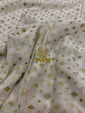 Textured fabric with gold floral patterns and a visible brand logo.