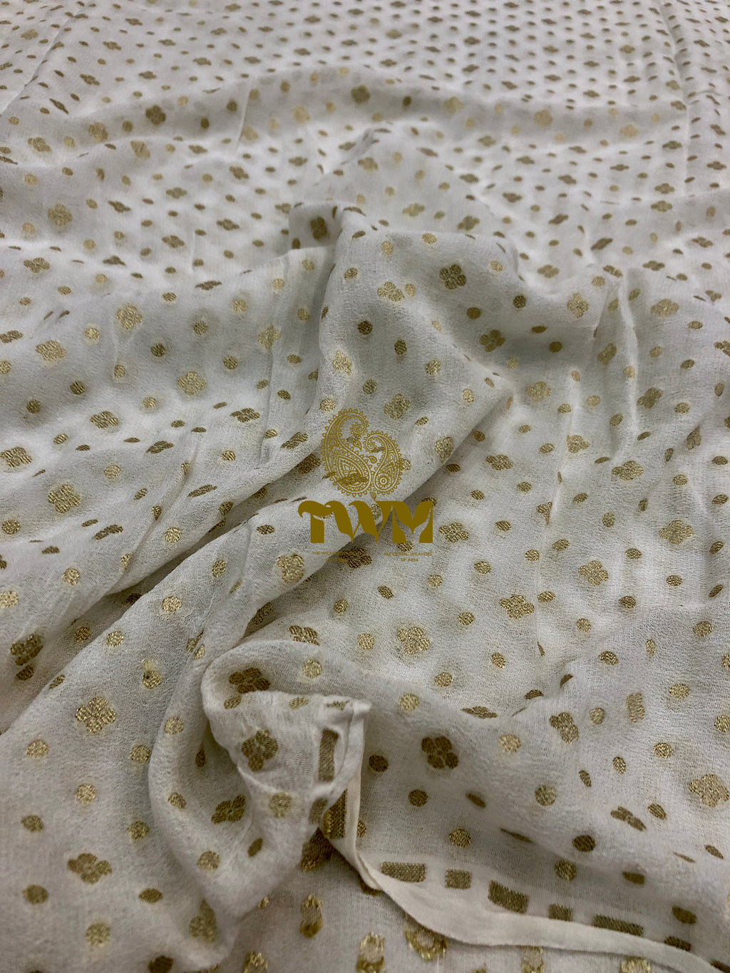 White fabric with gold floral patterns and 'NAM' branding.
