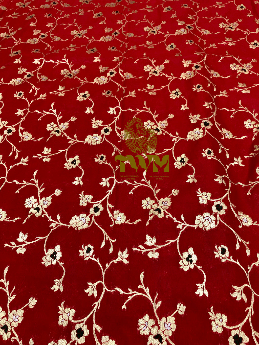 Red fabric with white floral pattern and a brand logo in the center