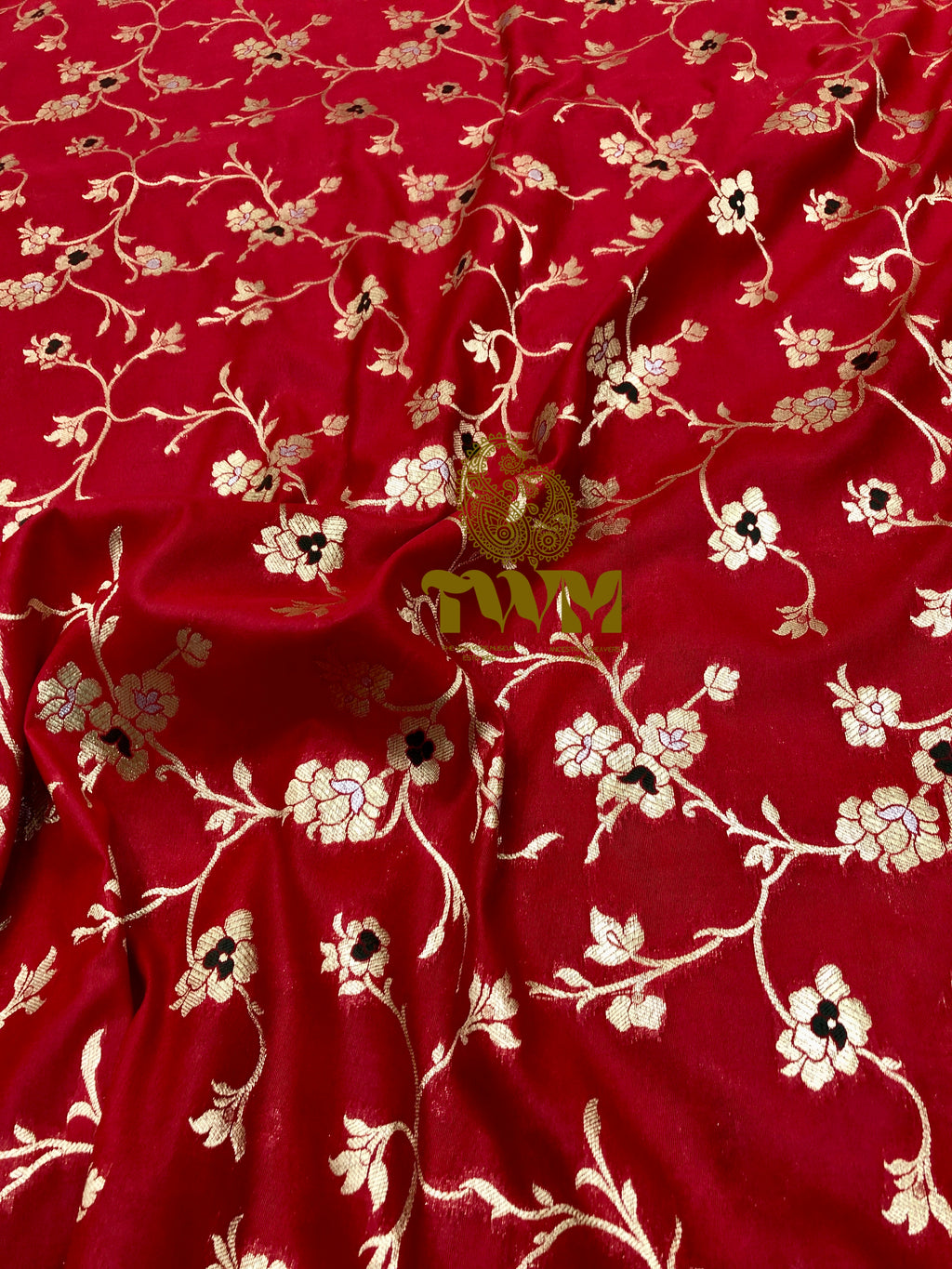 Red fabric with floral pattern and visible brand name.