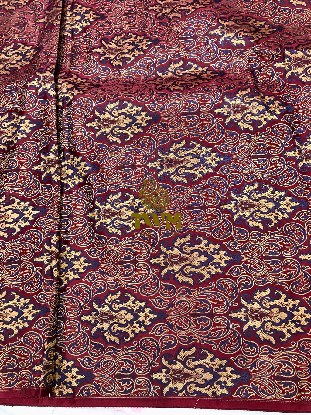 Close-up of a patterned fabric with intricate designs on a red background