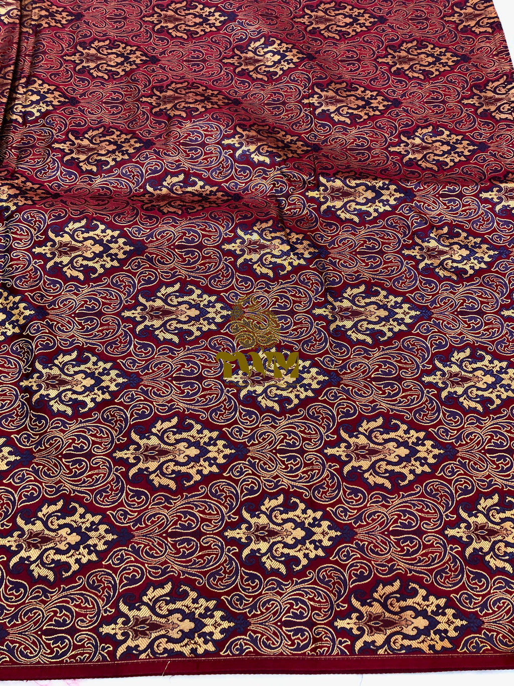Close-up of patterned fabric with intricate design on a red background