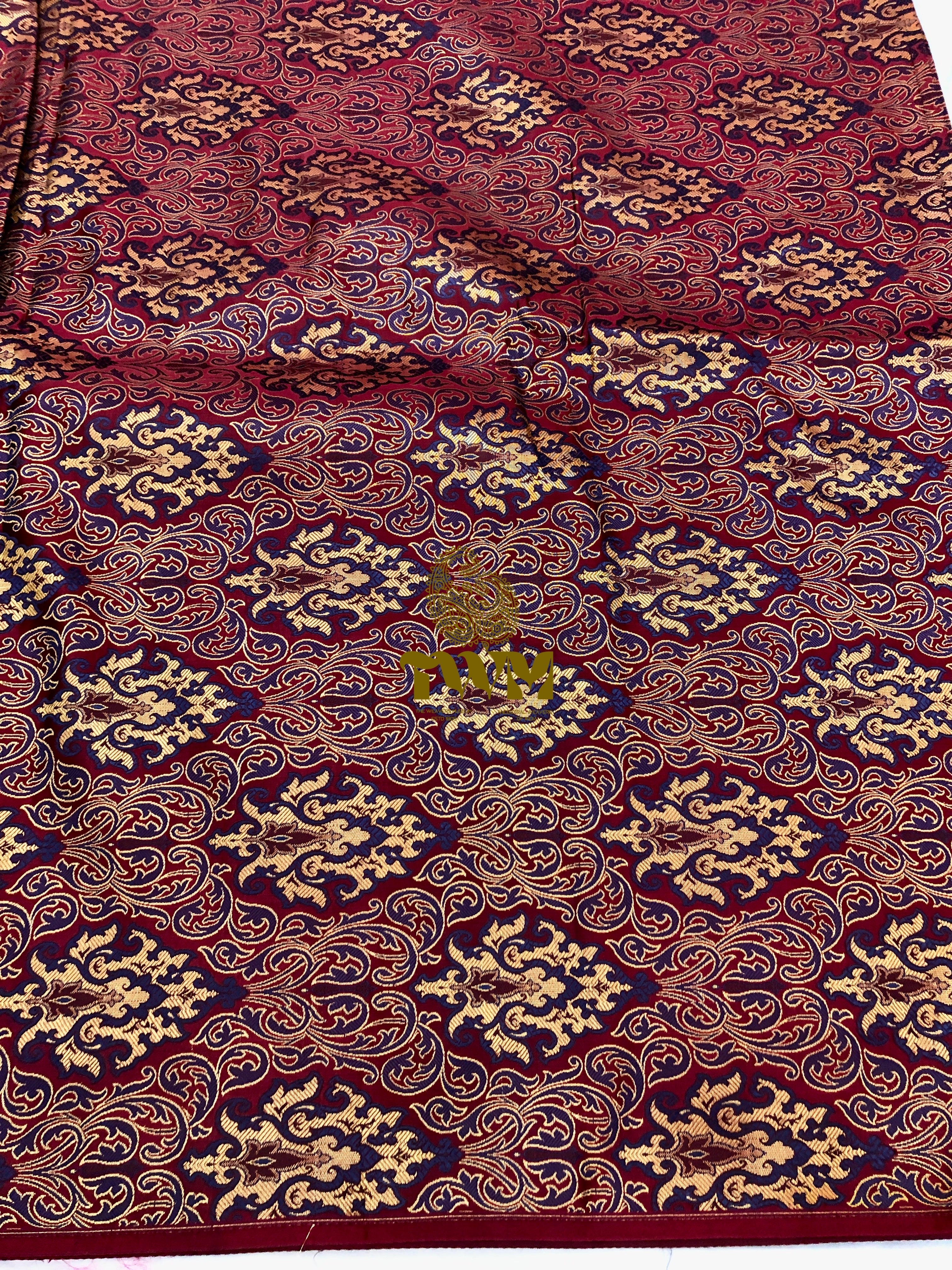 Close-up of patterned fabric with intricate design on a red background