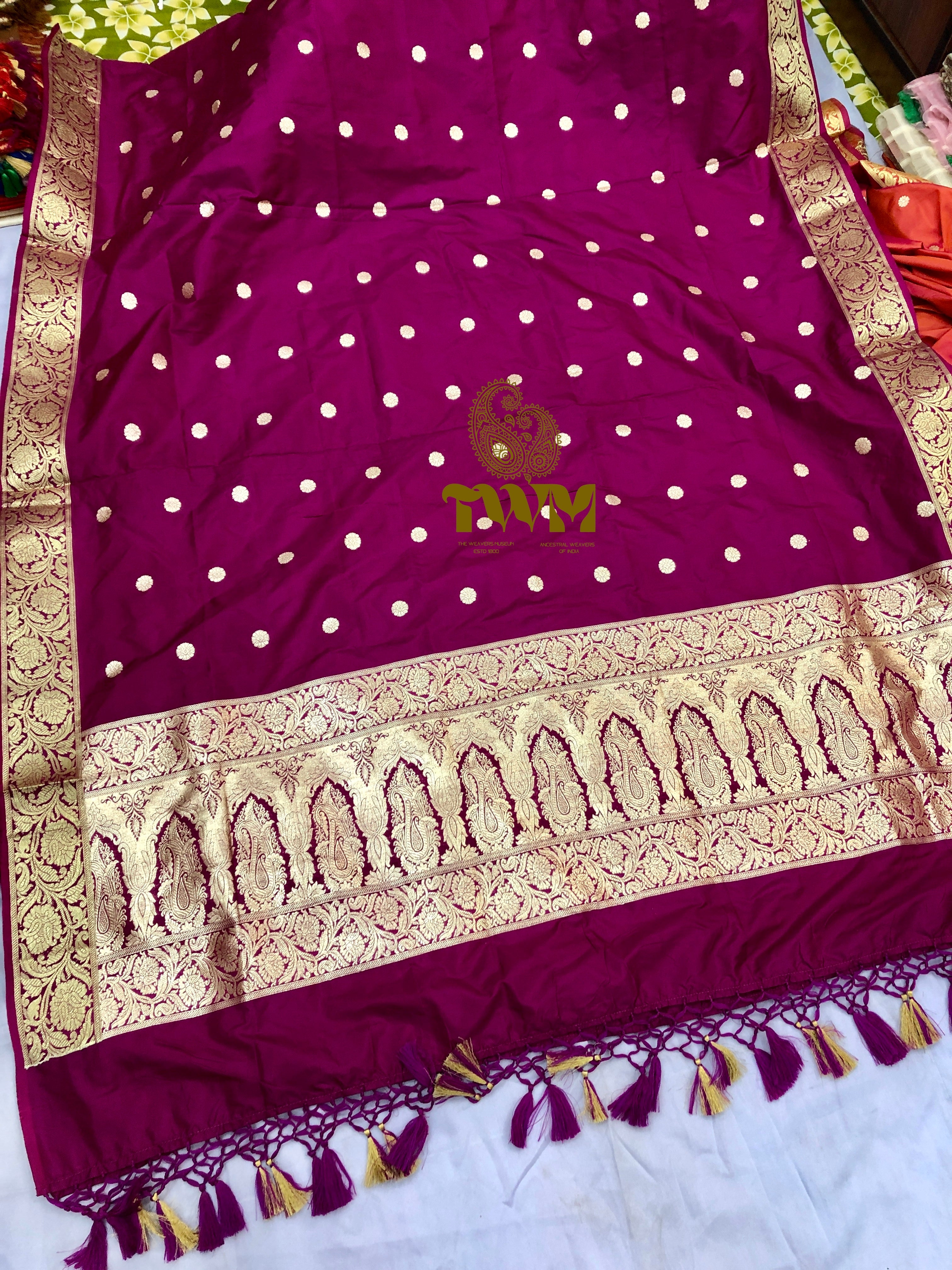 Purple dupatta with white polka dots and gold embroidery on a plain background