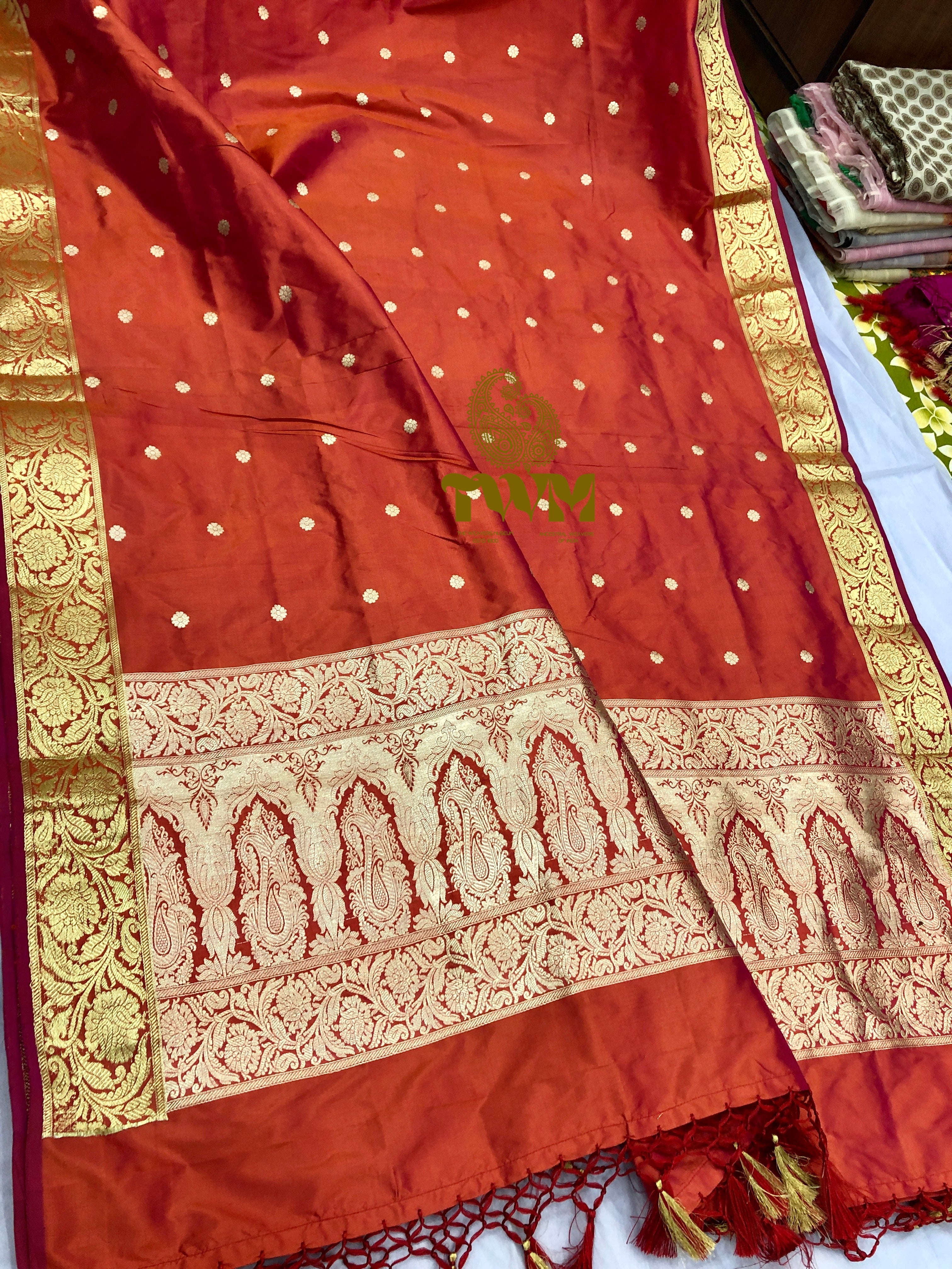 Orange dupatta with gold and white patterns on a plain background