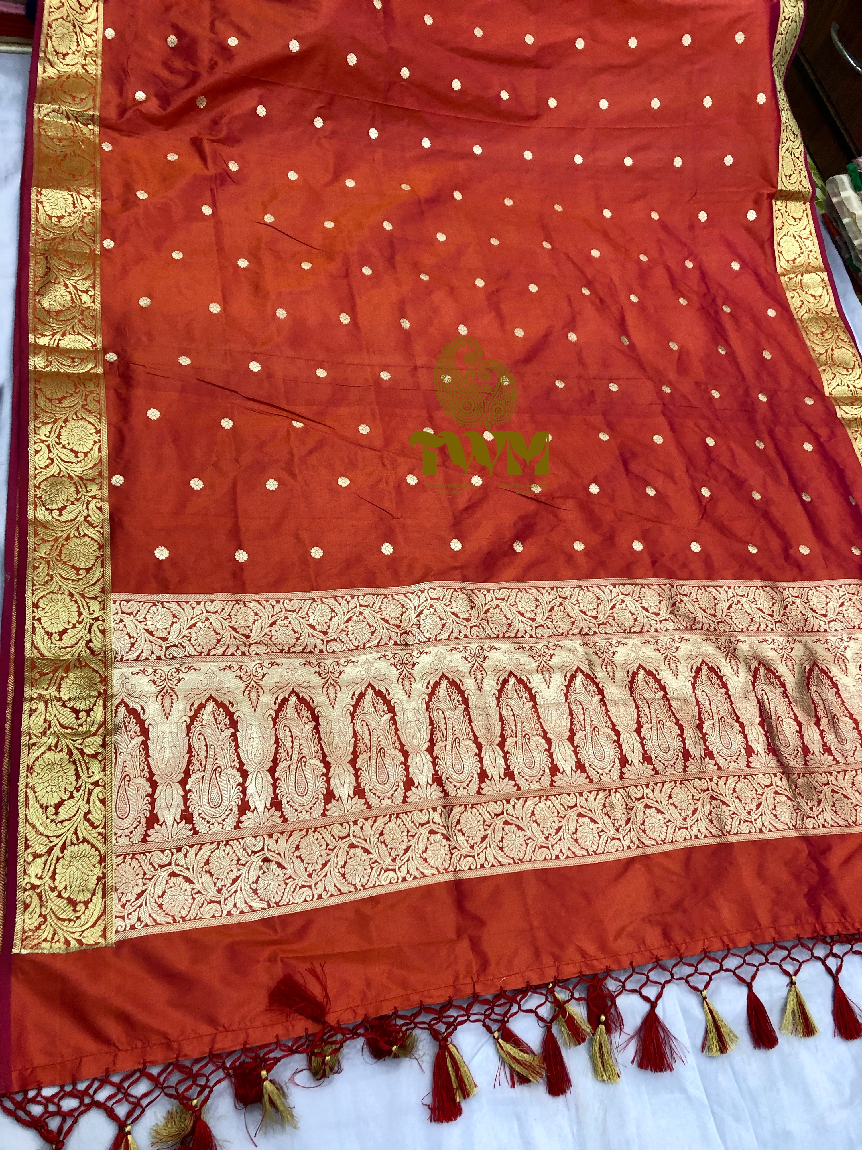 Orange dupatta with gold patterns and a logo on a white background