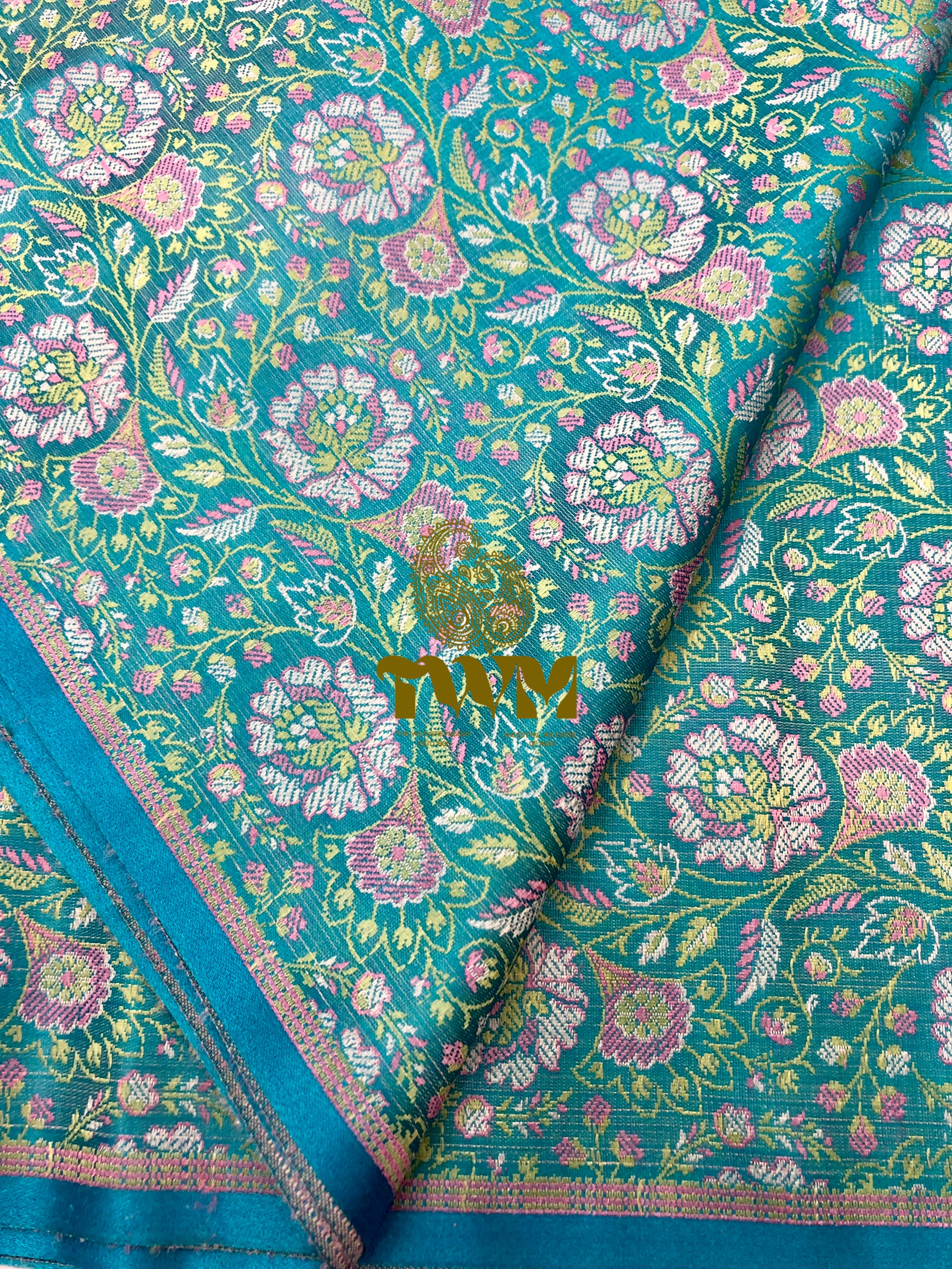 Teal fabric with floral pattern and 'TWM' text