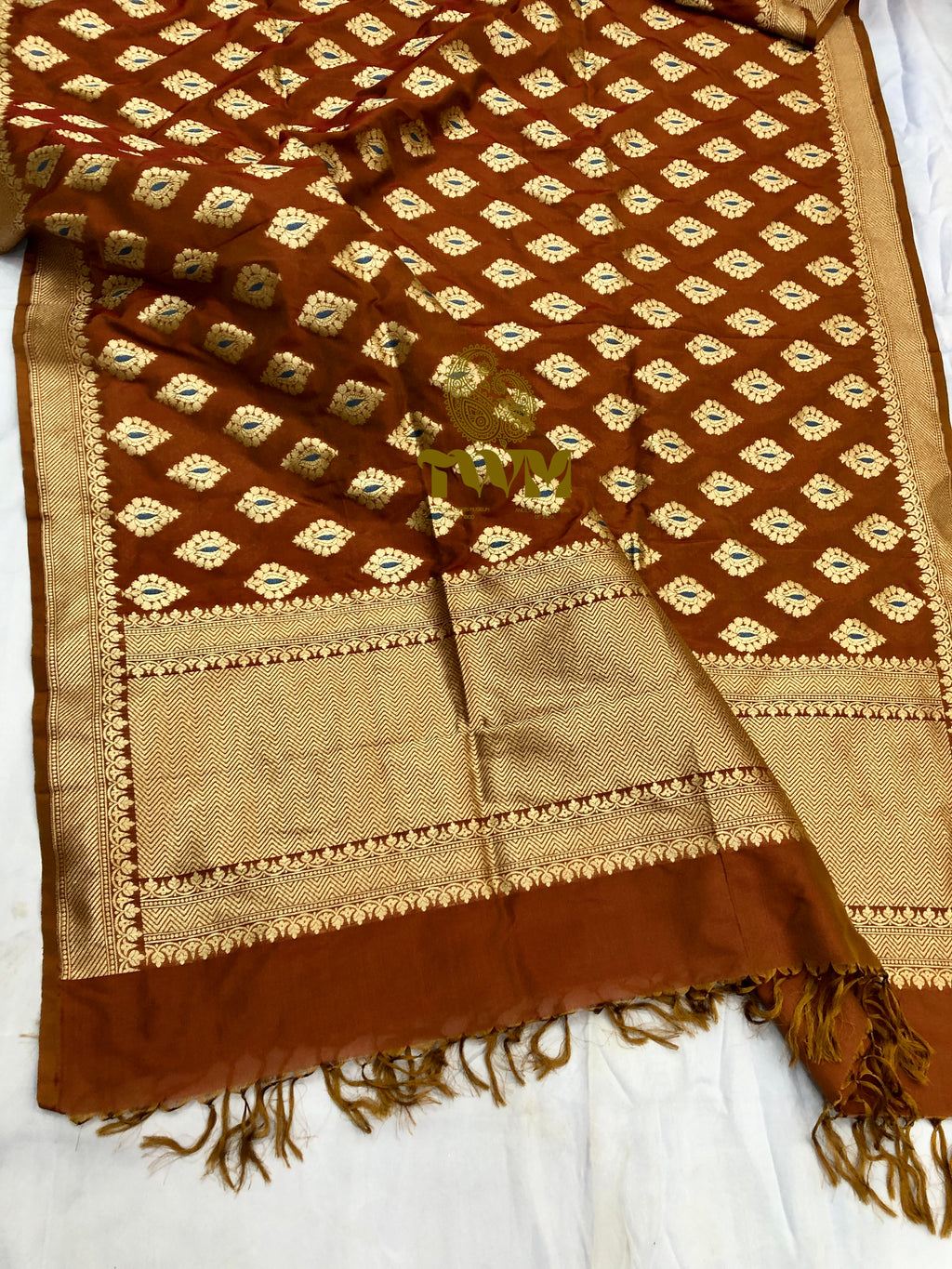 Brown and beige patterned fabric with tassels on a white background