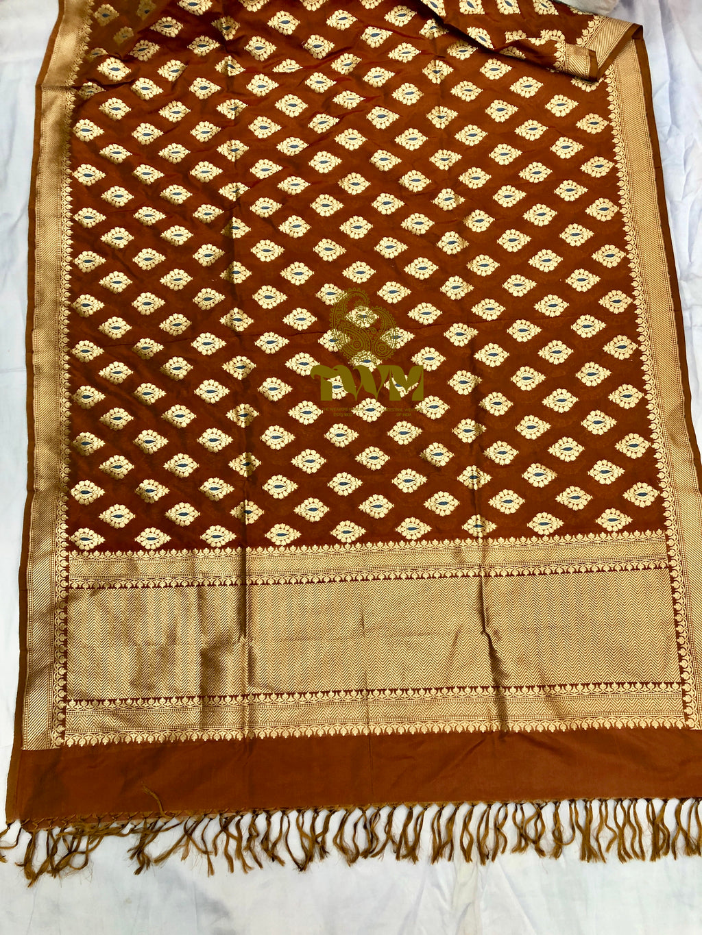 Brown and beige patterned fabric with fringes on a white background