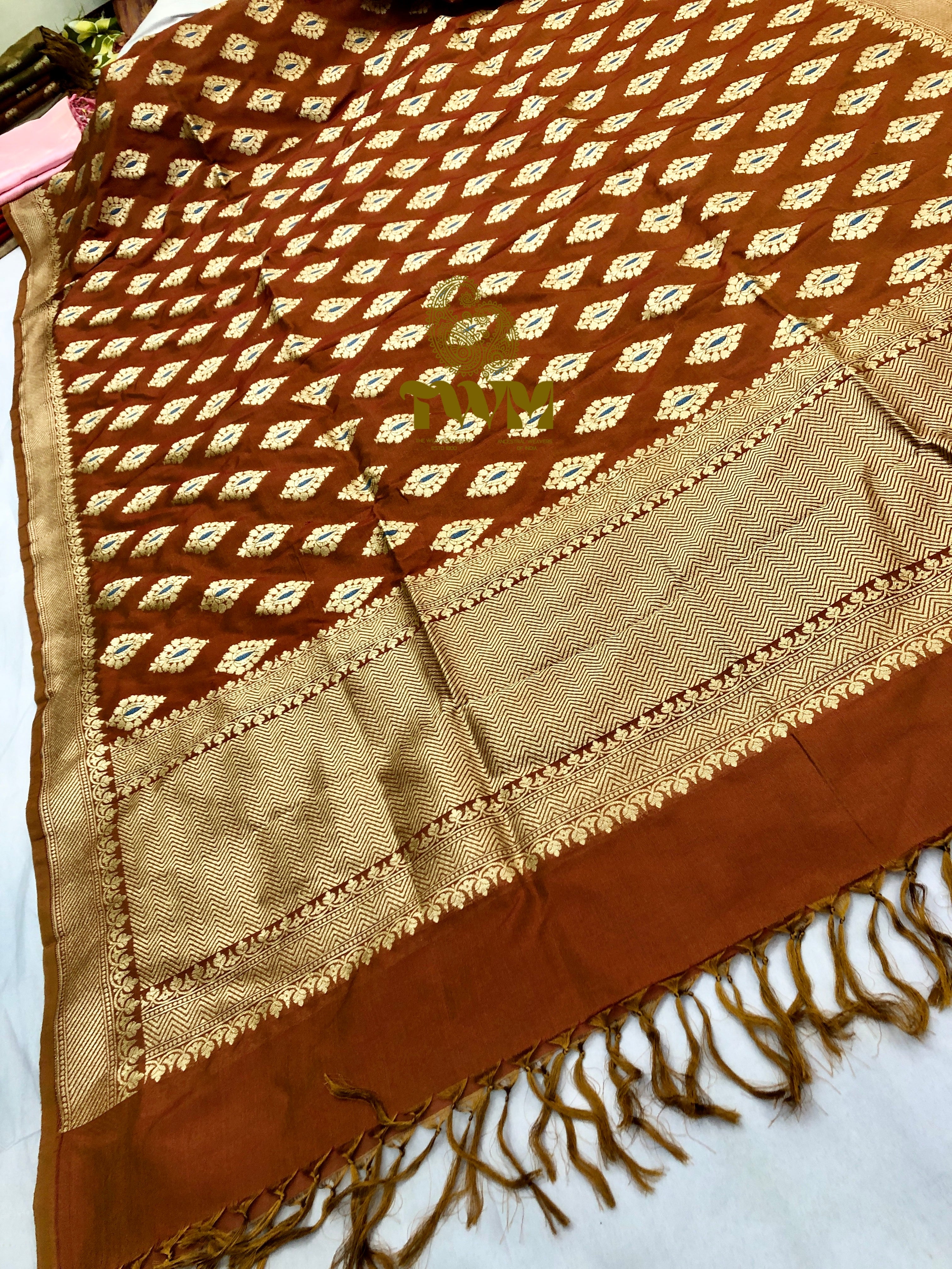 Brown and beige patterned fabric with fringes on a white background